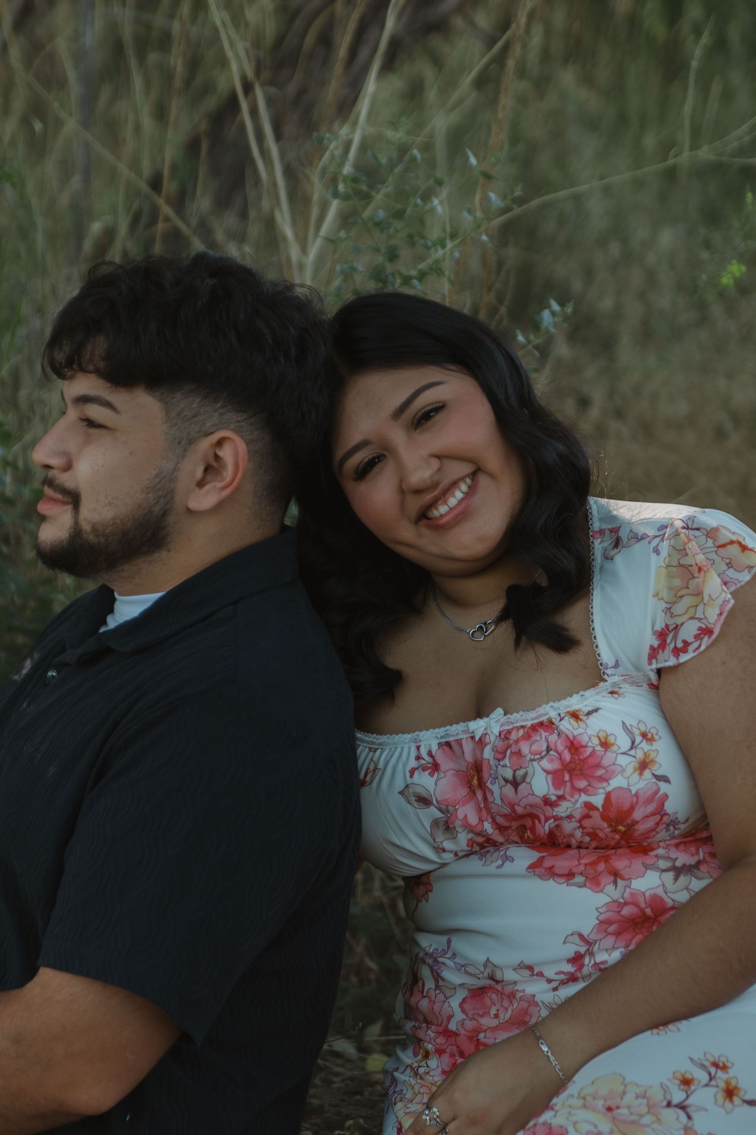 Romantic couple's portrait session in natural setting with warm lighting.