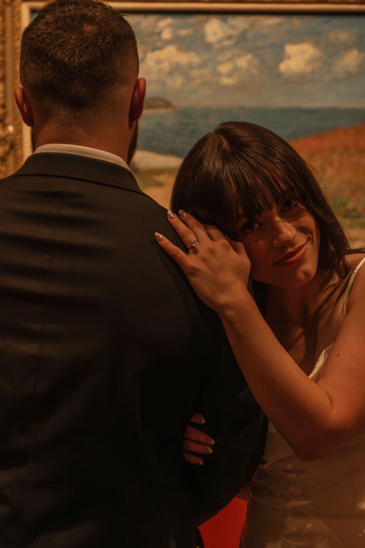 Intimate close-up shot of a romantic moment between a couple at sunset with a golden-framed backdrop.