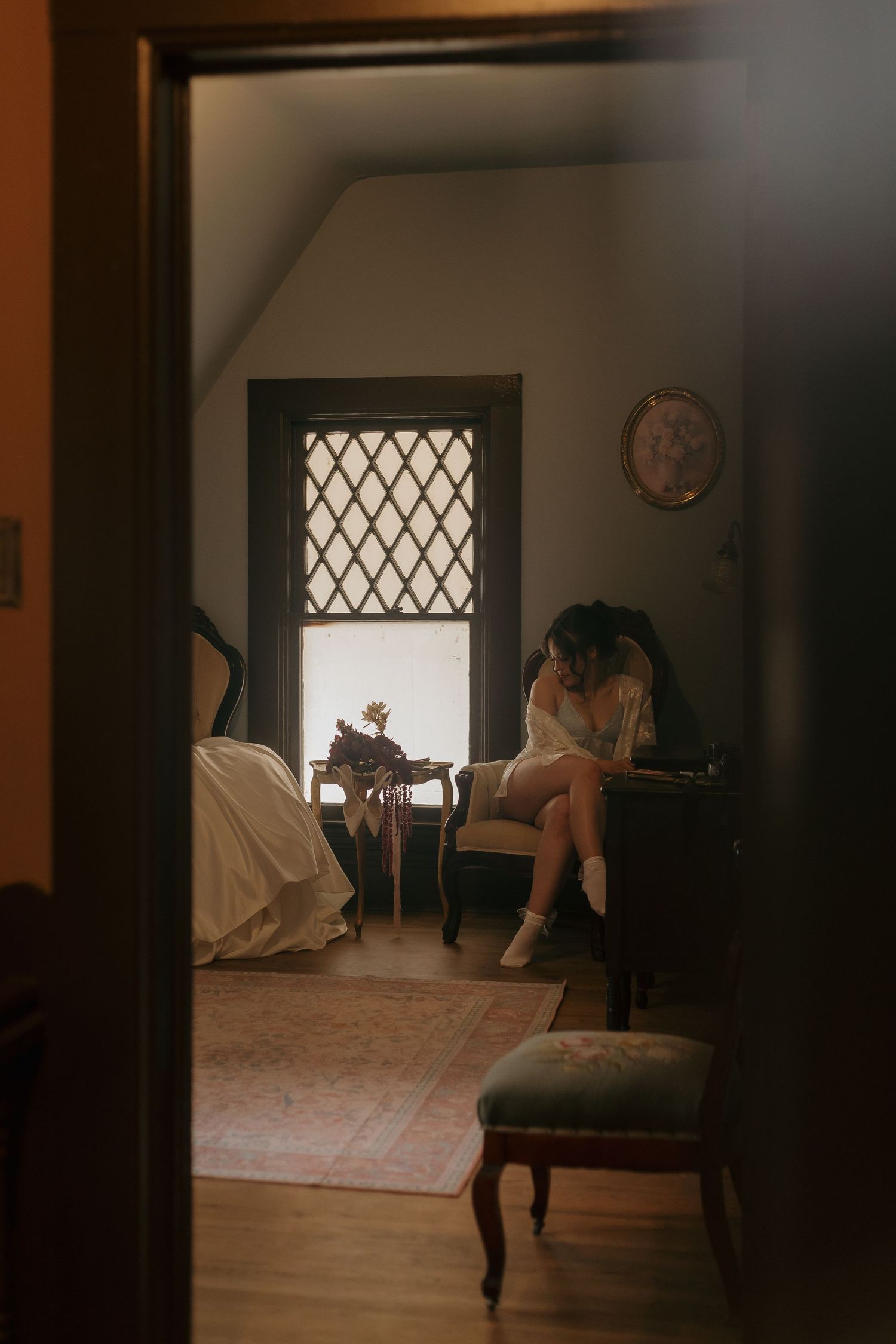 Moody vintage room interior with diamond-patterned window and antique furniture in warm sepia tones.