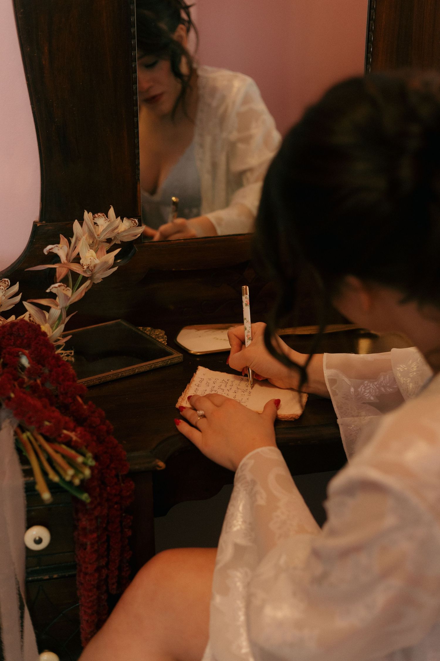 A couple shares an intimate moment during their wedding ceremony with white flowers in the background.