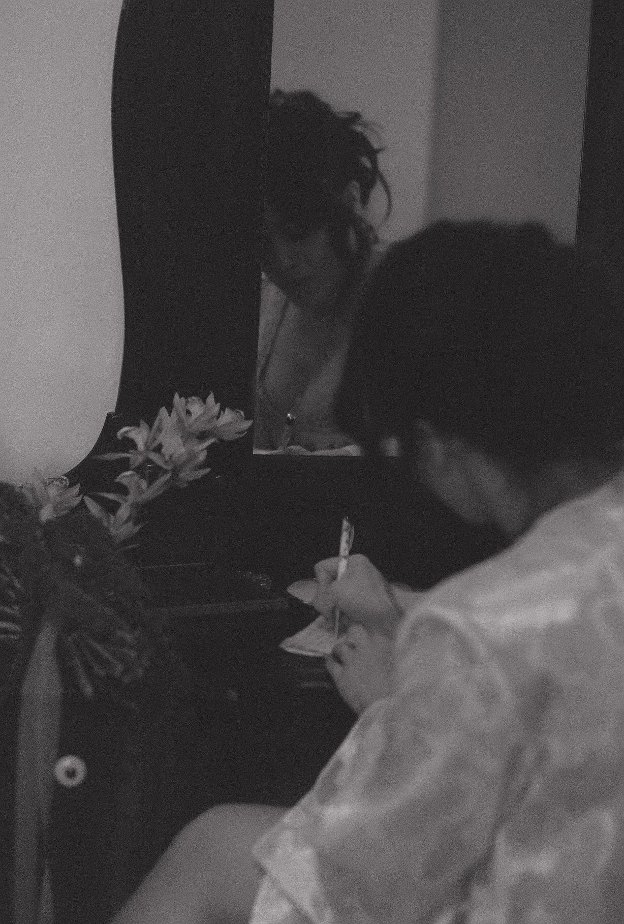 A black and white candid moment of wedding preparations.
