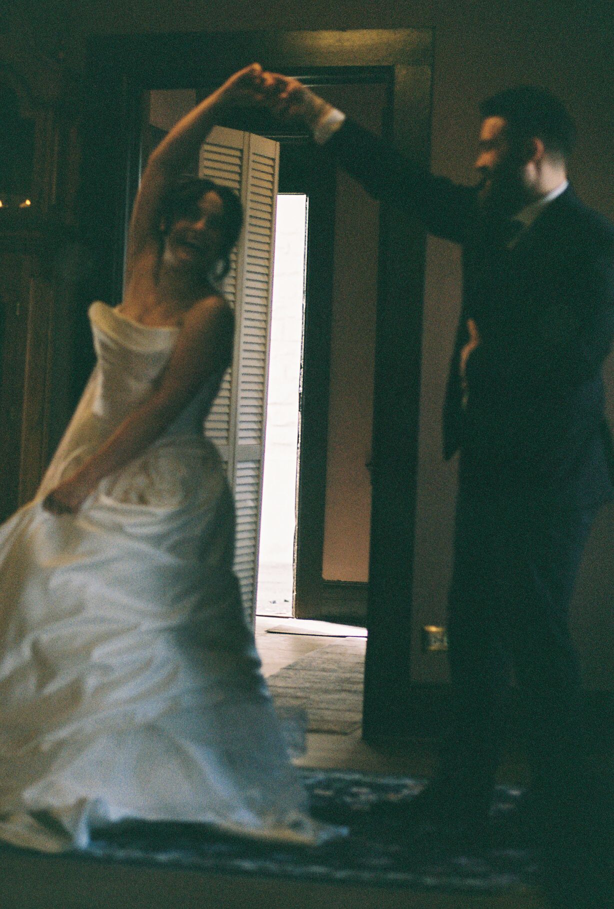 Artistic motion blur captures dancing couple in elegant wedding attire.