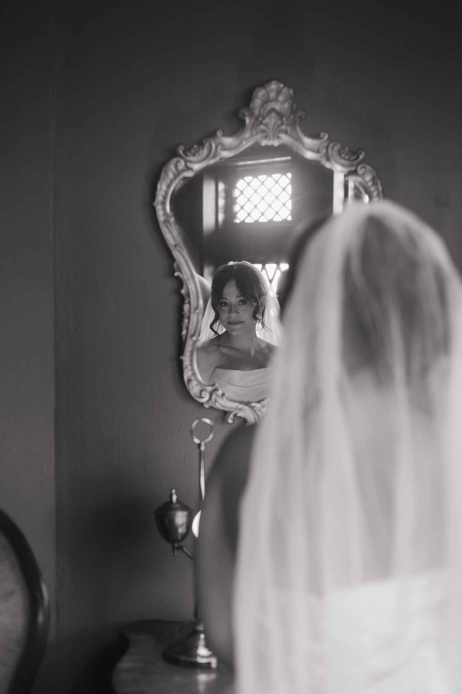 Black and white sequence showing bride's reflection in ornate mirror with window light.
