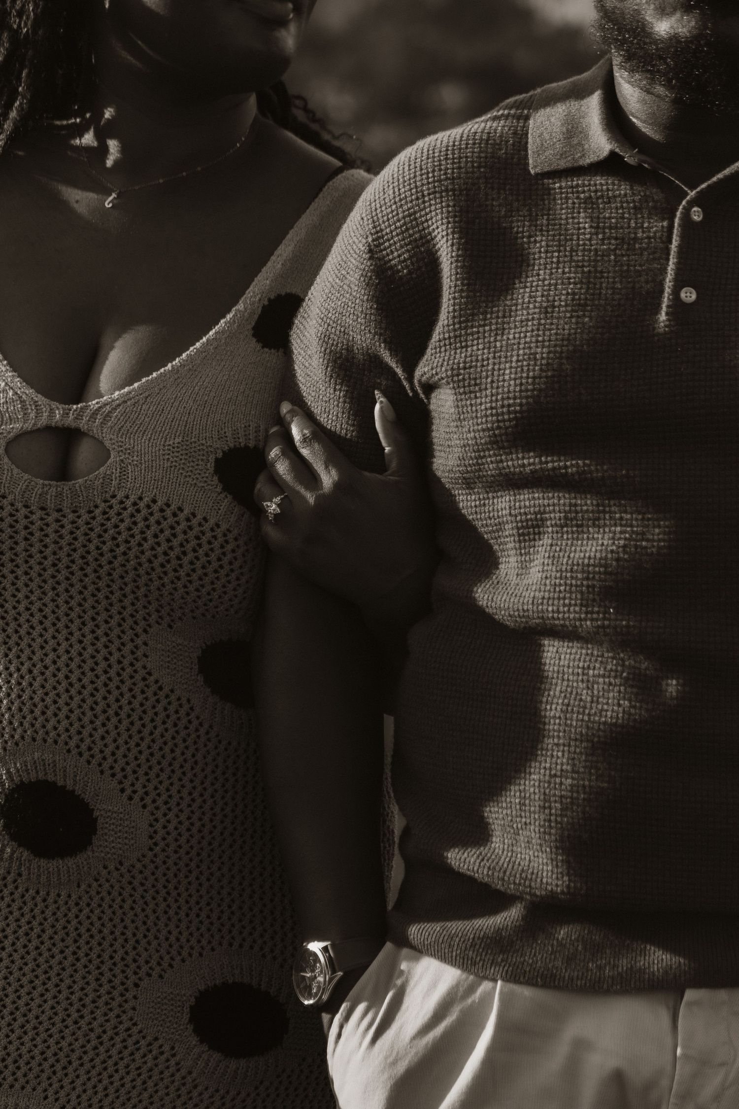 An intimate black and white portrait showing details of textured knit sweaters.