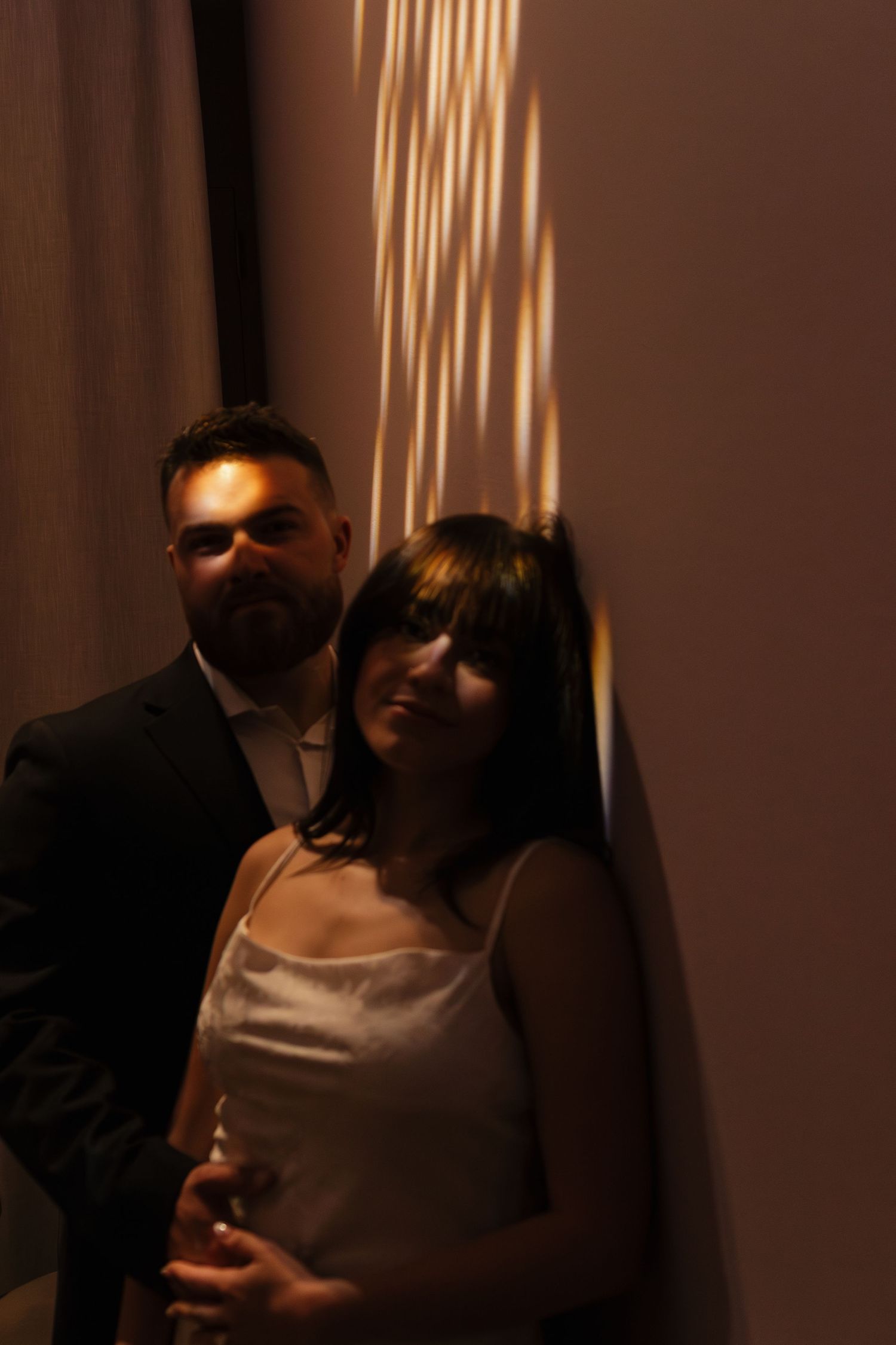 A romantic moment captured in dramatic shadows and lighting at an art gallery.