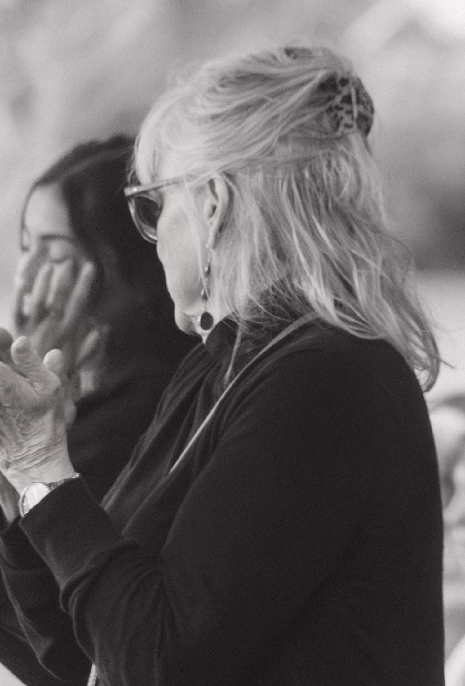 A side profile of someone with blonde hair wearing black during an emotional moment.