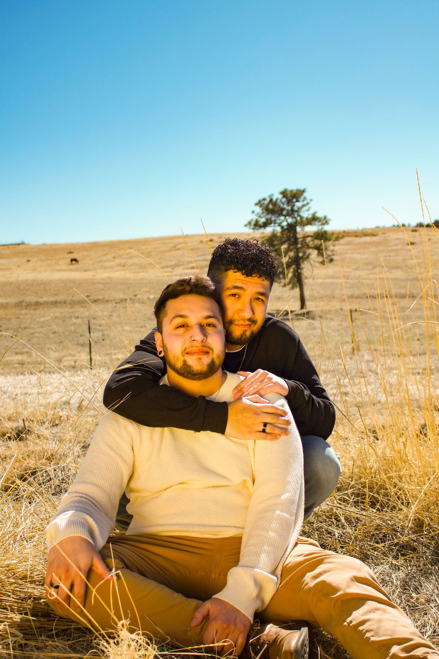 Intimate outdoor portrait of two people sitting in golden field.