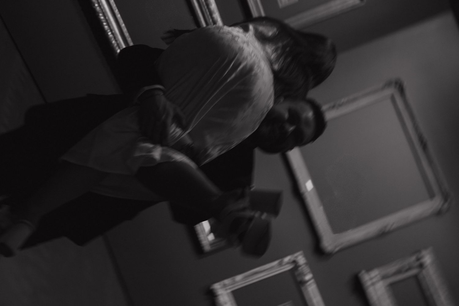 High-angle black and white shots in an indoor space with dramatic lighting.