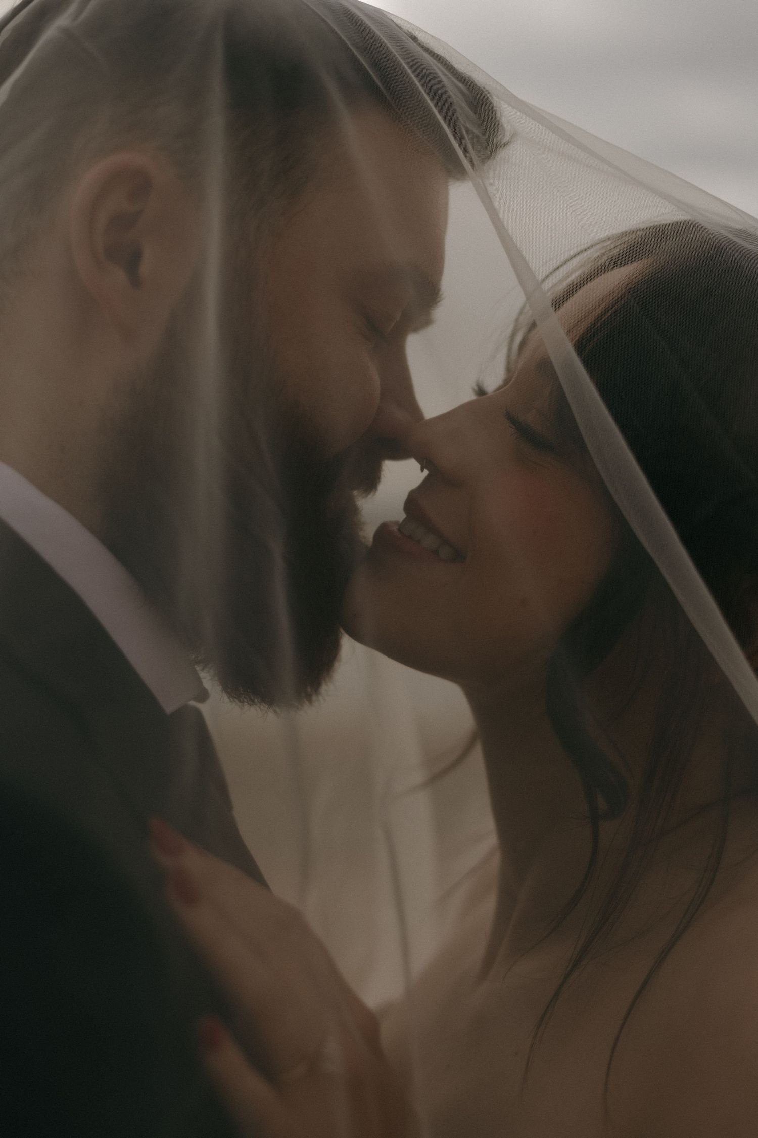 A romantic couple shares an intimate moment in soft, moody lighting.