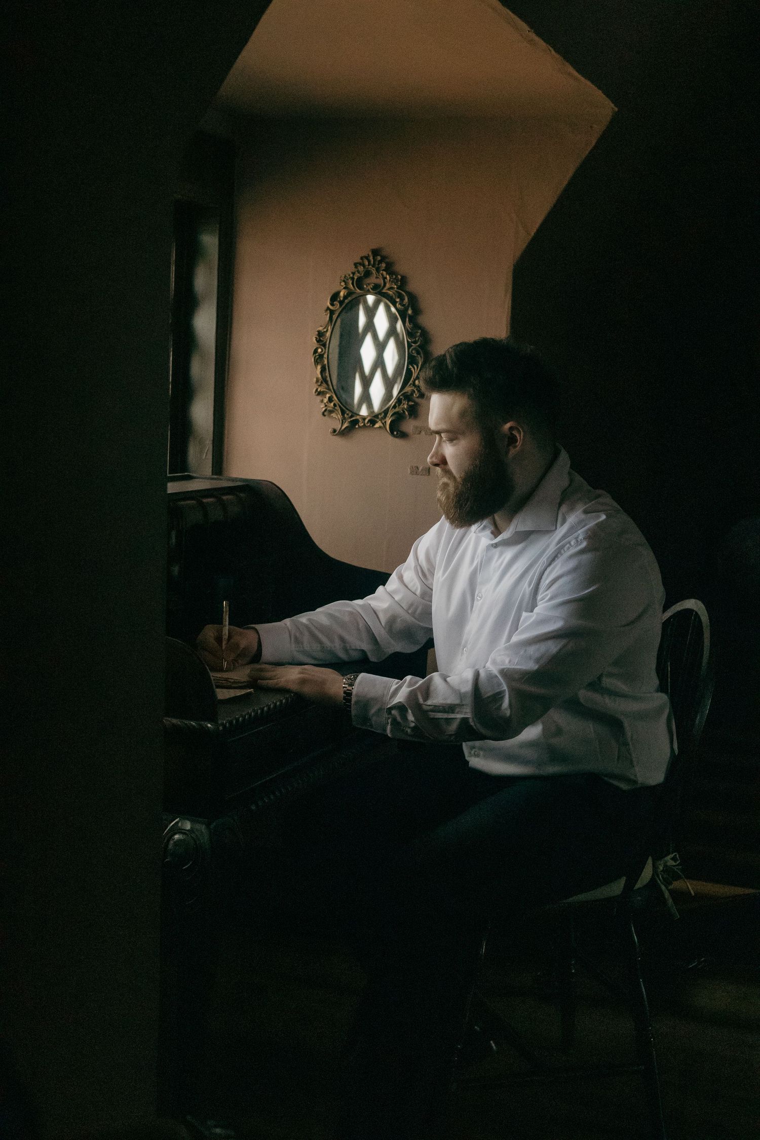 A person works at a dimly lit desk in a dark room illuminated by a soft glow.