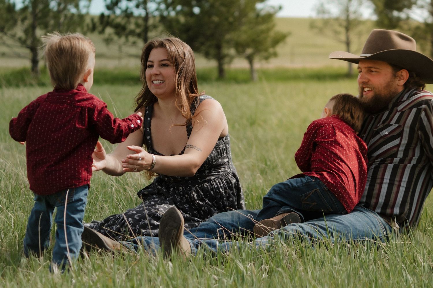 A family relaxing together on grass in a scenic outdoor setting.