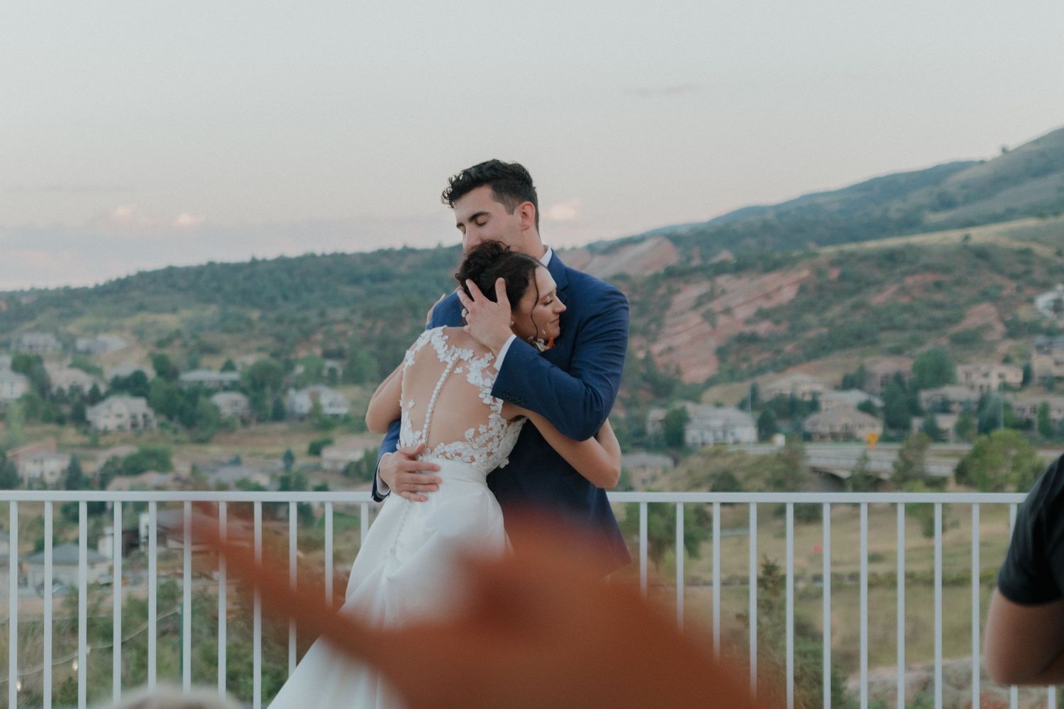 A romantic moment shared during a sunset dip on an outdoor terrace with mountains in the background.