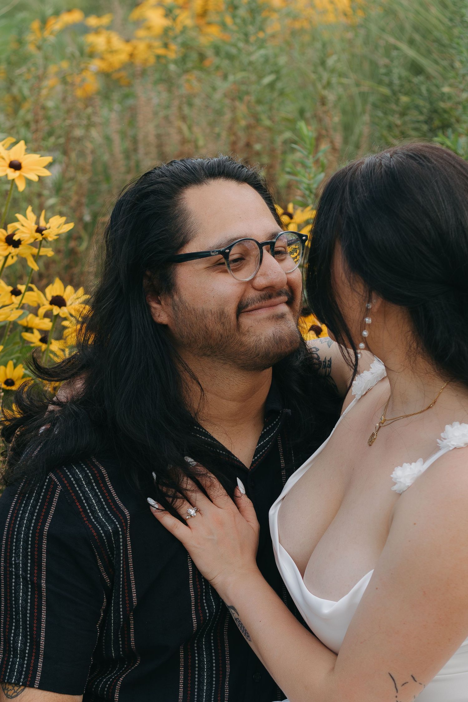 A romantic outdoor portrait with yellow wildflowers blooming in the background.