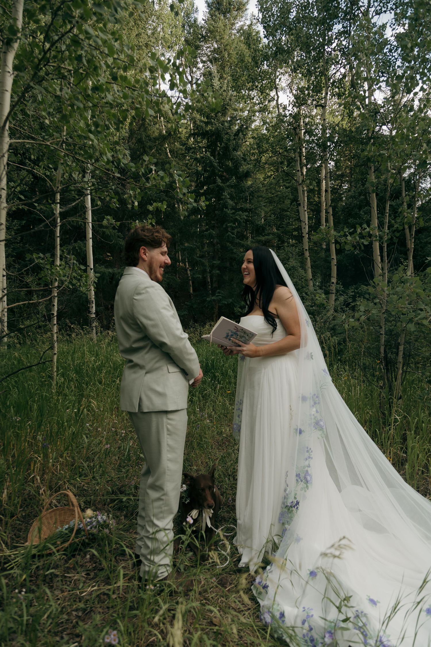 Bride and groom exchange vows in a lush aspen forest during intimate outdoor elopement.