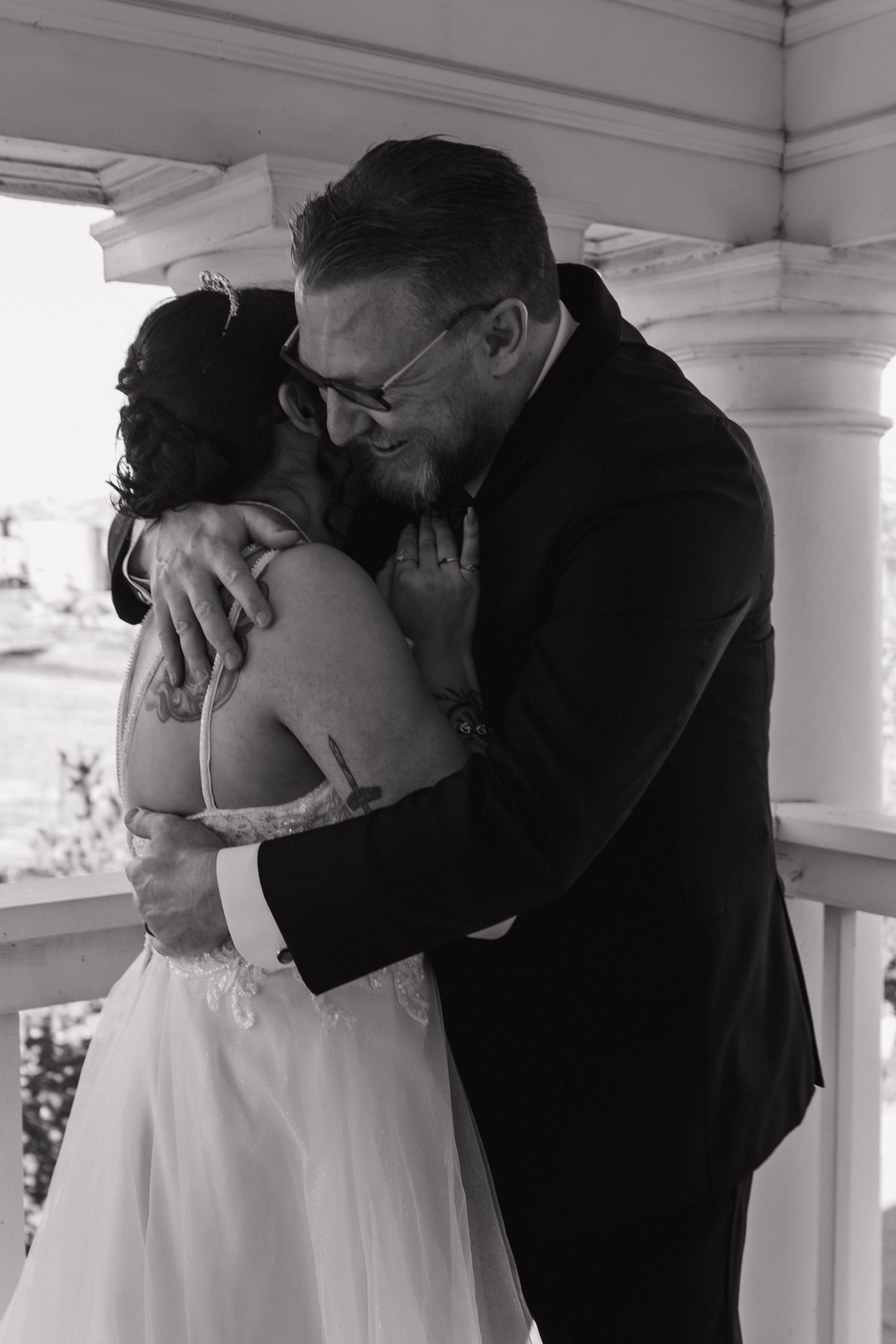 A romantic black and white photo series showing a couple sharing their first kiss as newlyweds on a porch.