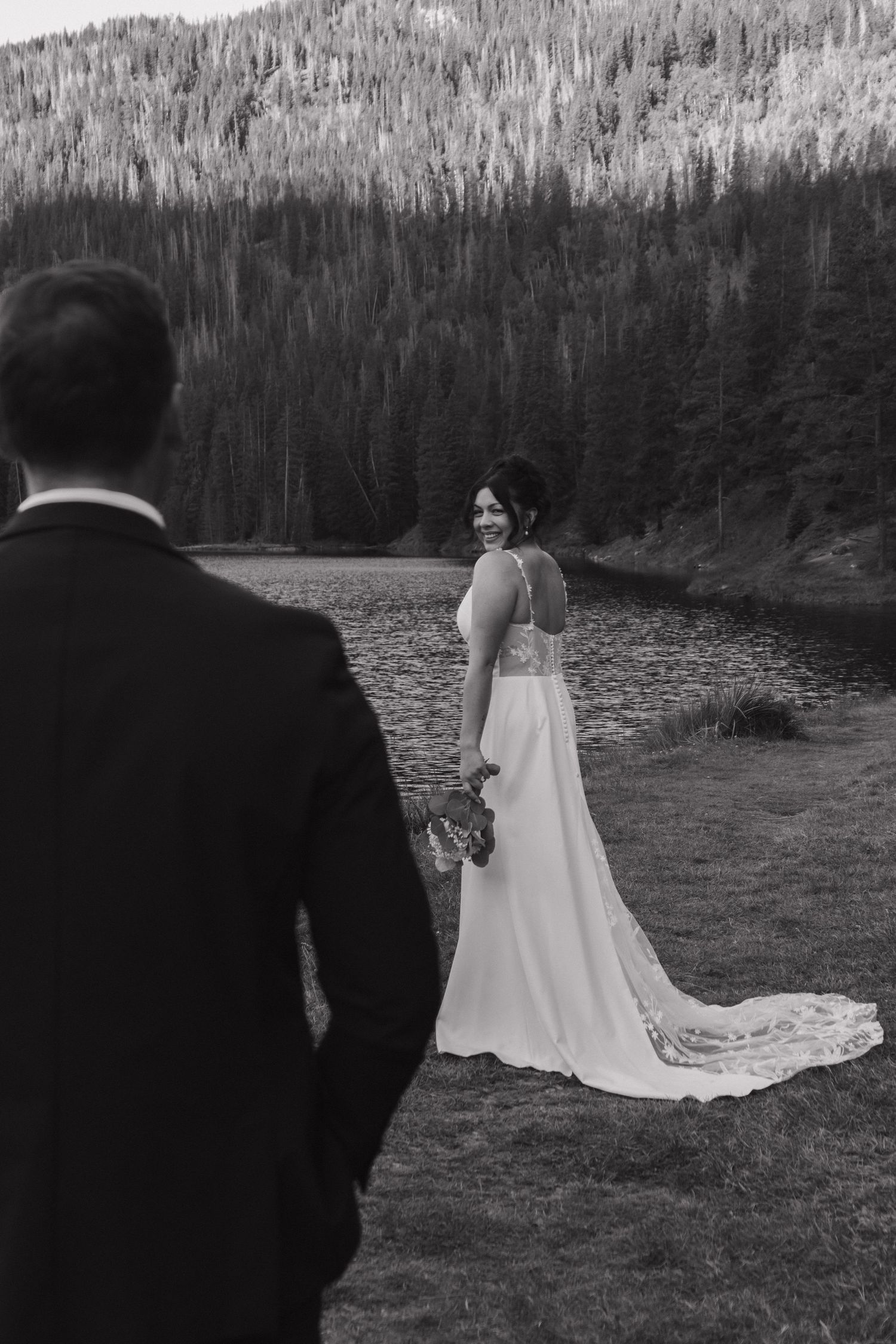A wedding photoshoot with mountain ranges and a serene lake creating a dramatic backdrop.