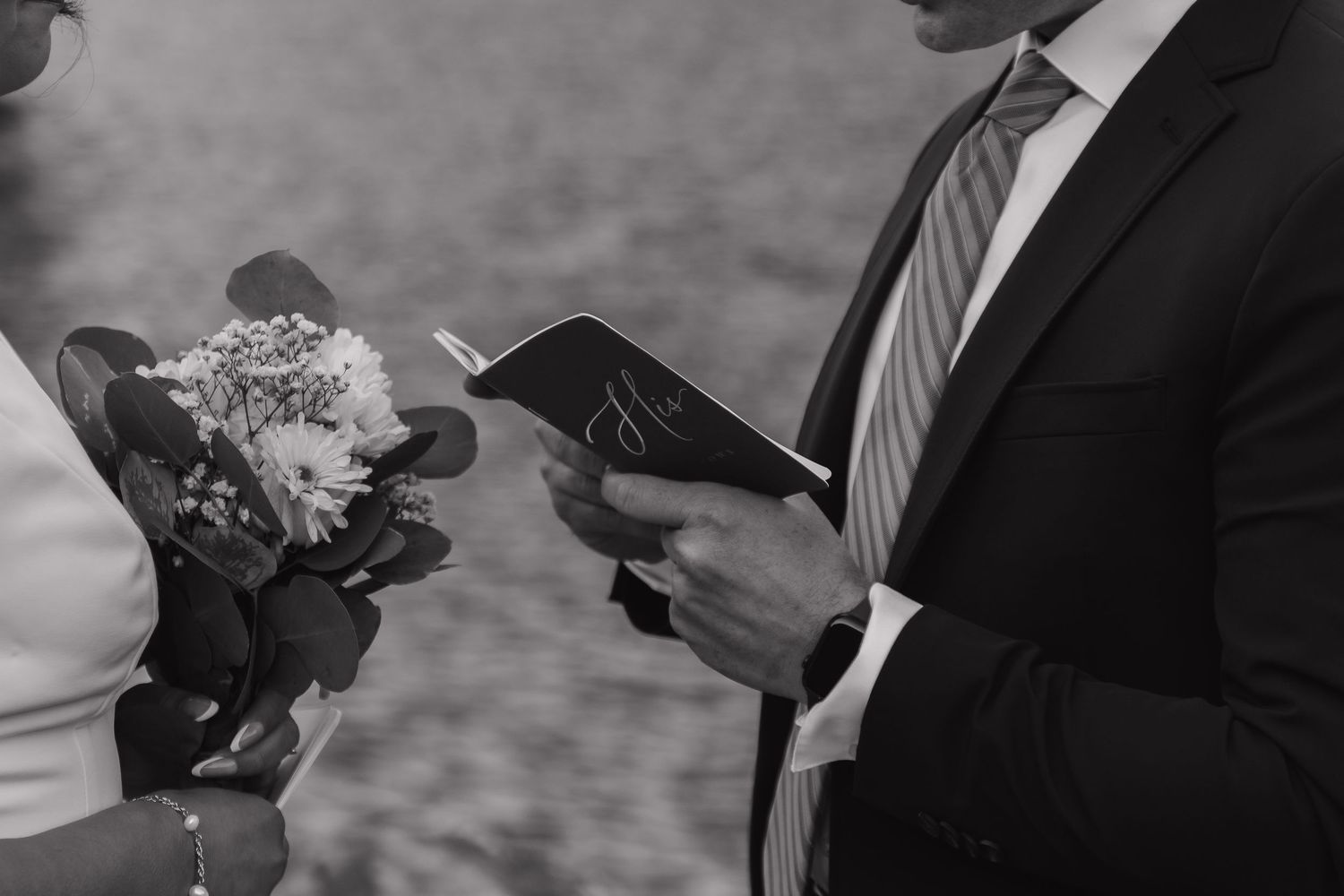 Close-up of wedding rings being exchanged during an outdoor ceremony.