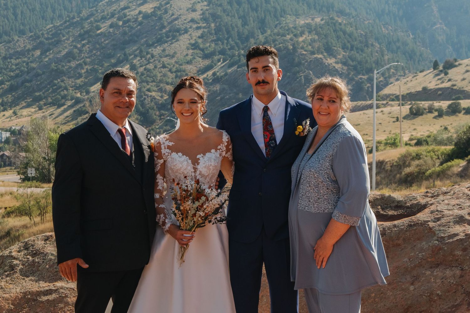 Wedding ceremony taking place against scenic mountain landscape.