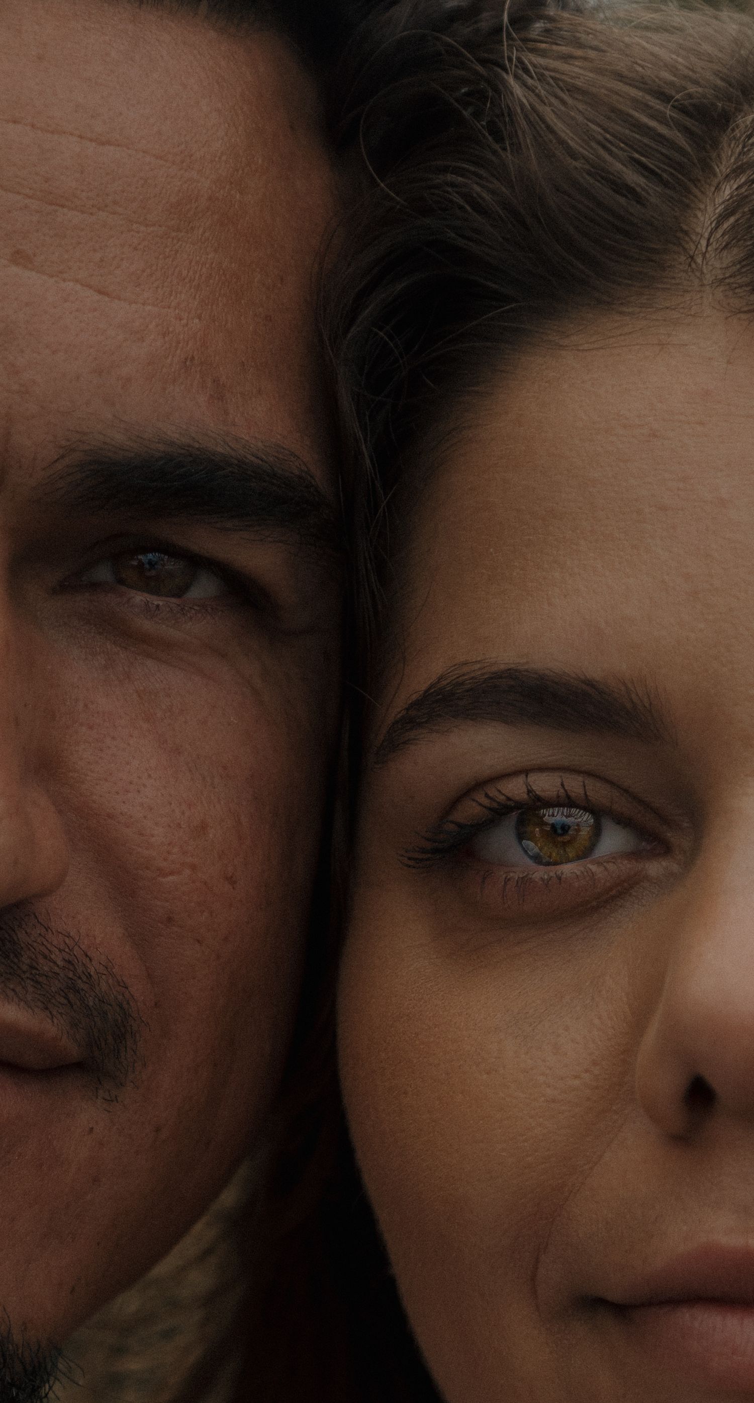 Intimate close-up portrait of a mans and womans faces side by side, both with striking hazel eyes.