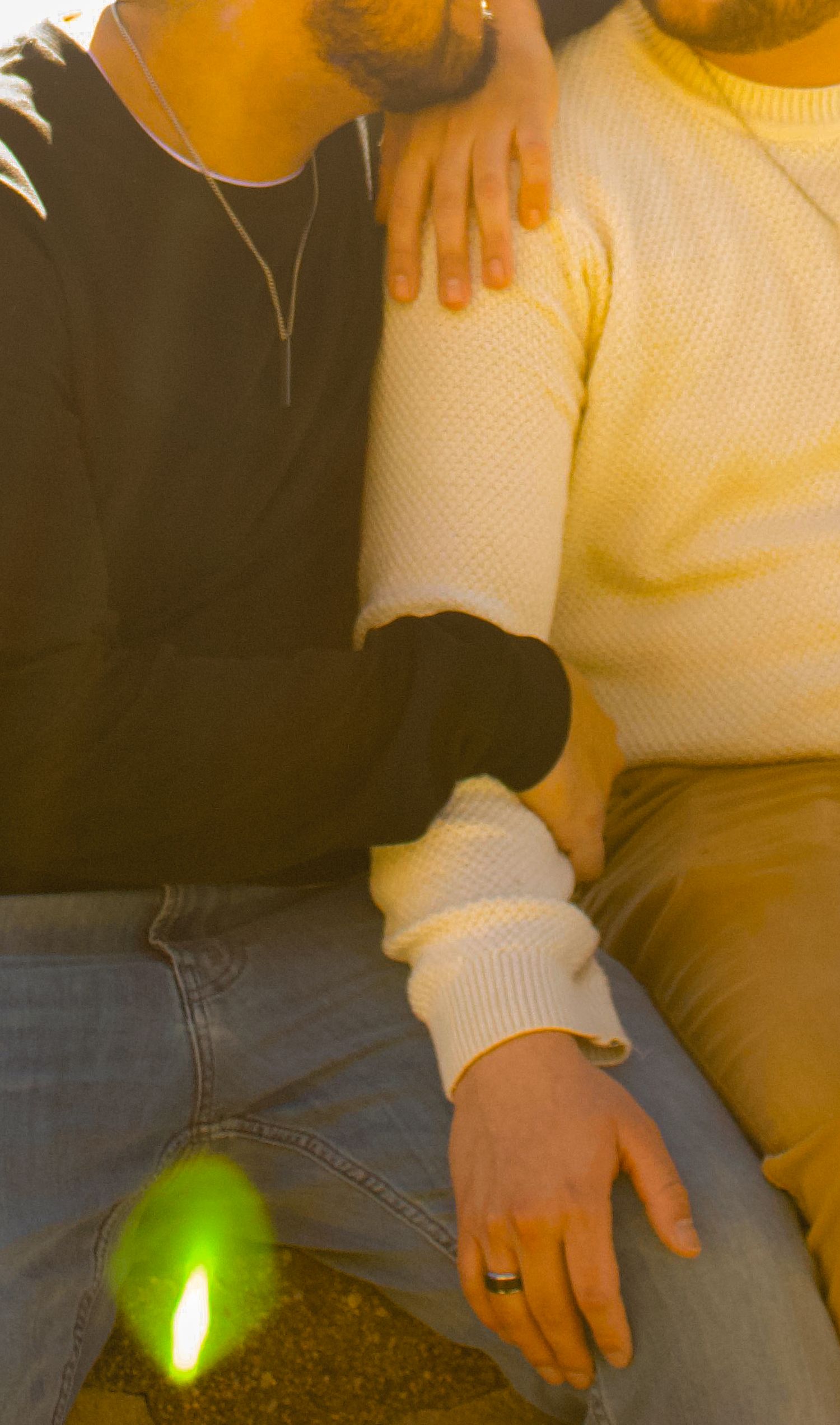 Person in cream sweater sitting with green light glowing nearby.