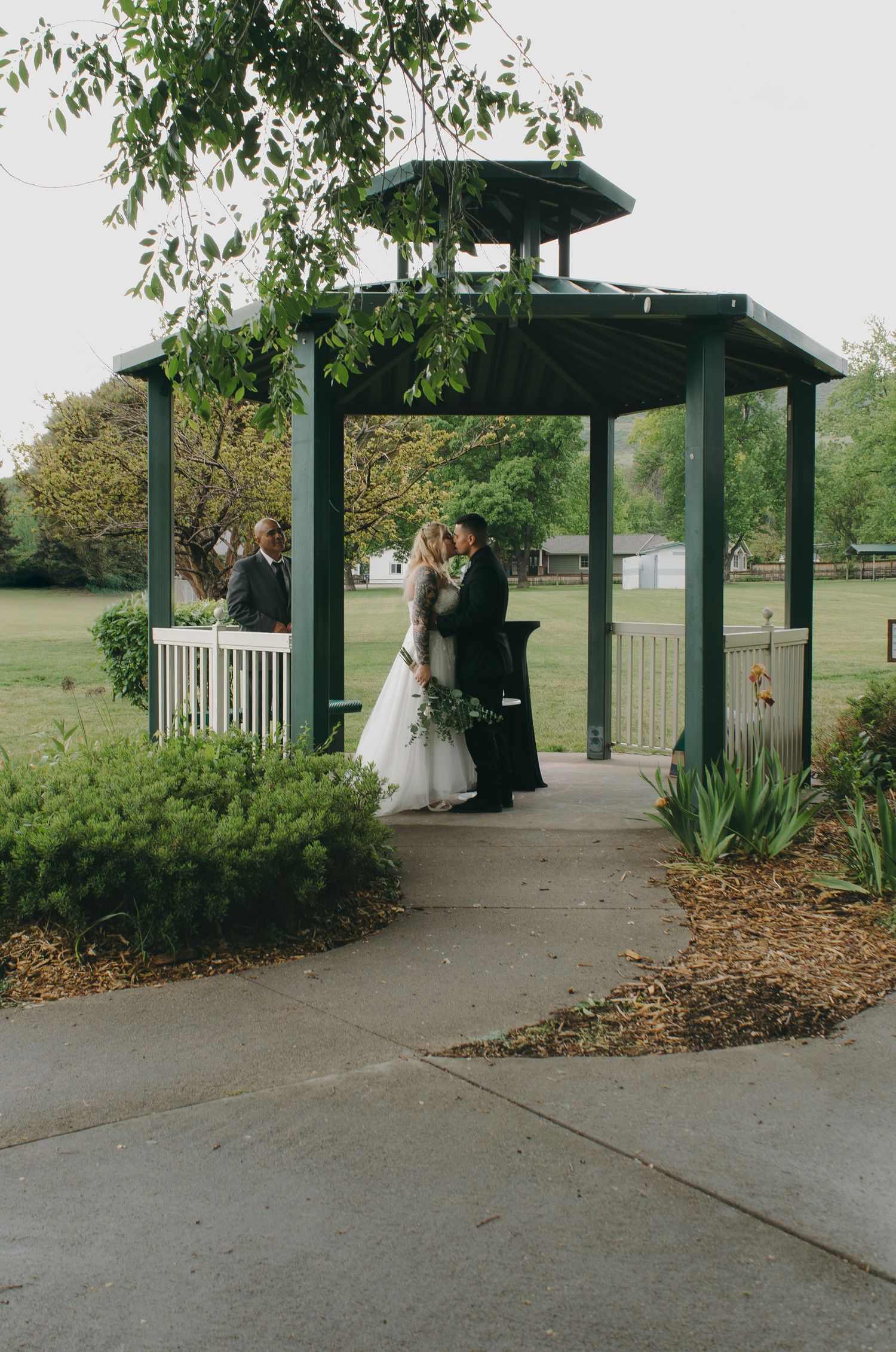 Sequential shots of a wedding ceremony in a park pavilion with green landscaping.
