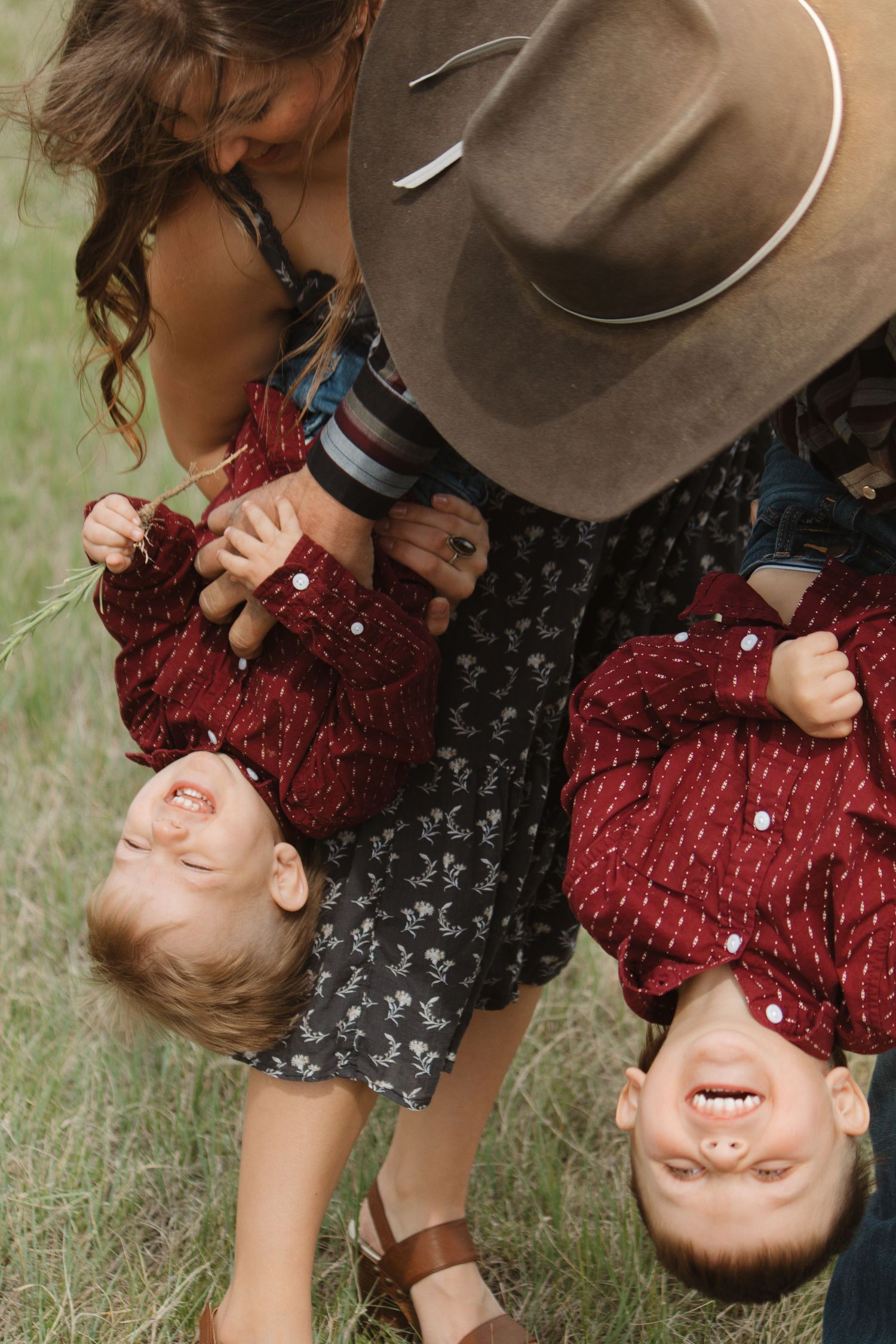 Playful upside down portrait of family laughing together in outdoor setting.