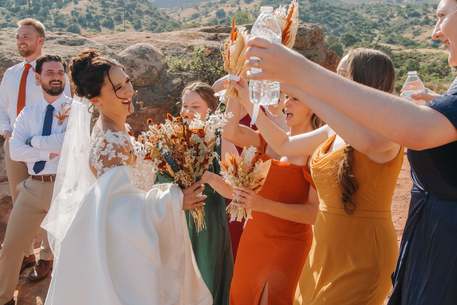 Wedding guests mingle at an outdoor reception with scenic mountain views.