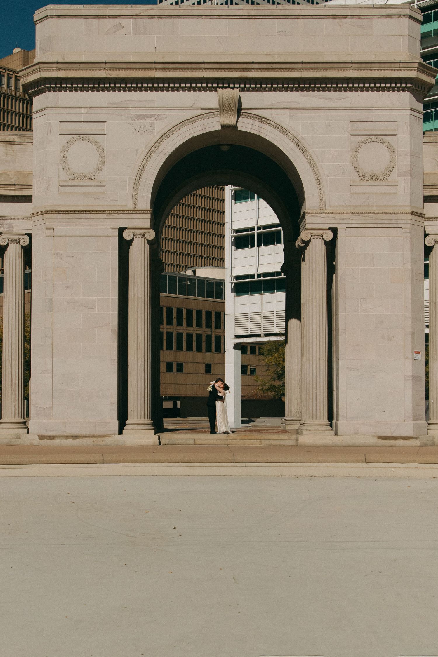 Classical stone archway with columns in warm sunlight.
