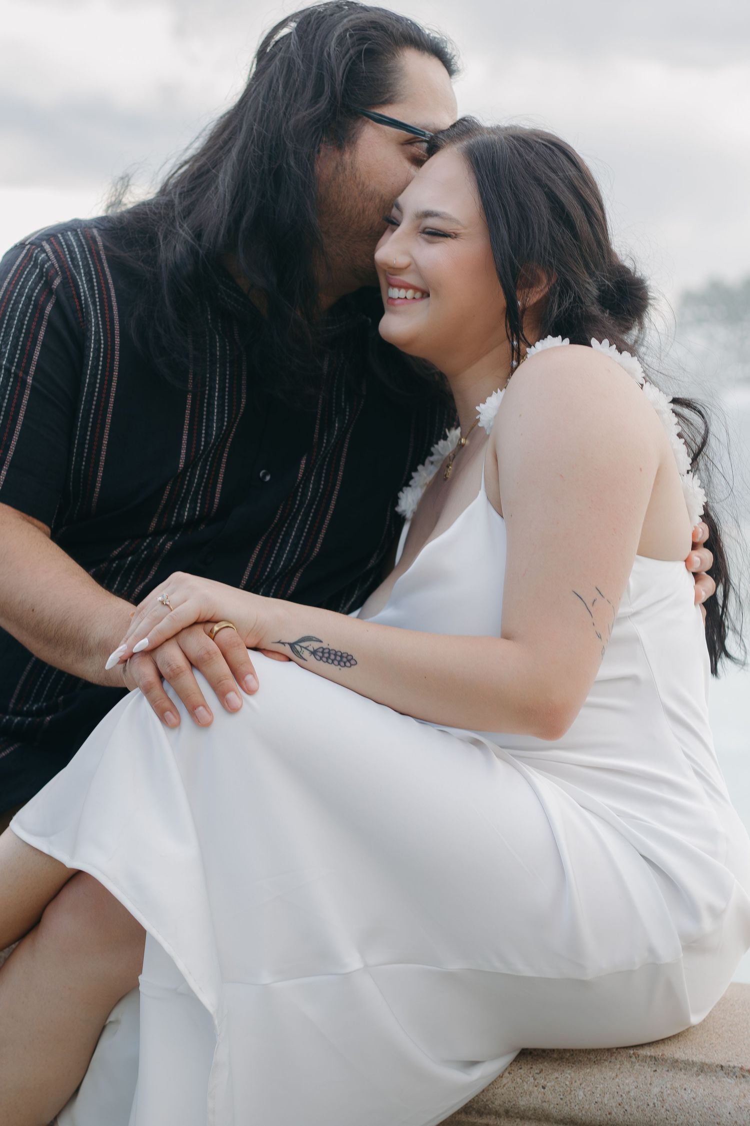 An intimate portrait of a couple sharing a joyful moment outdoors.