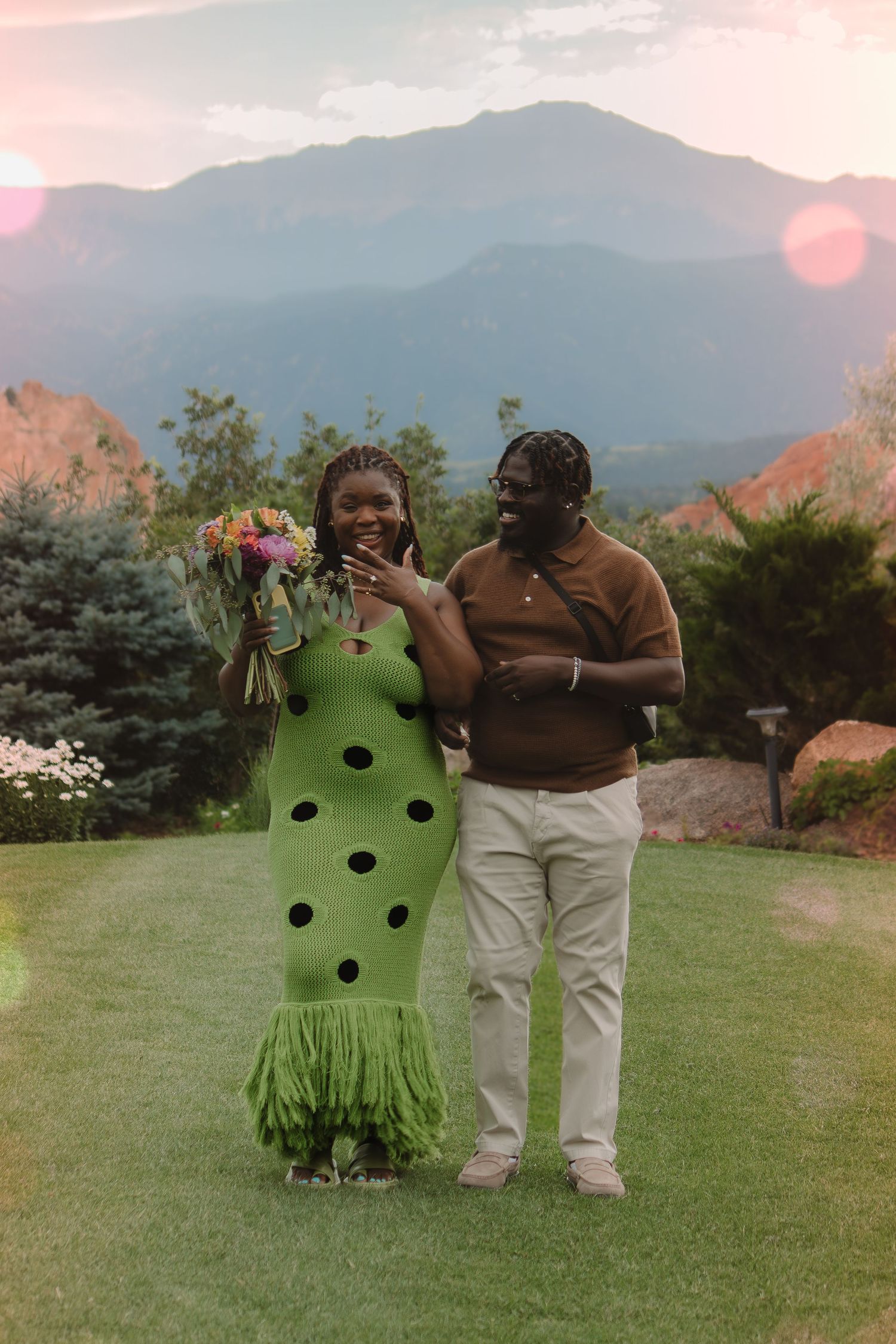 A romantic photoshoot in front of mountain scenery featuring colorful flowers and stylish outfits.