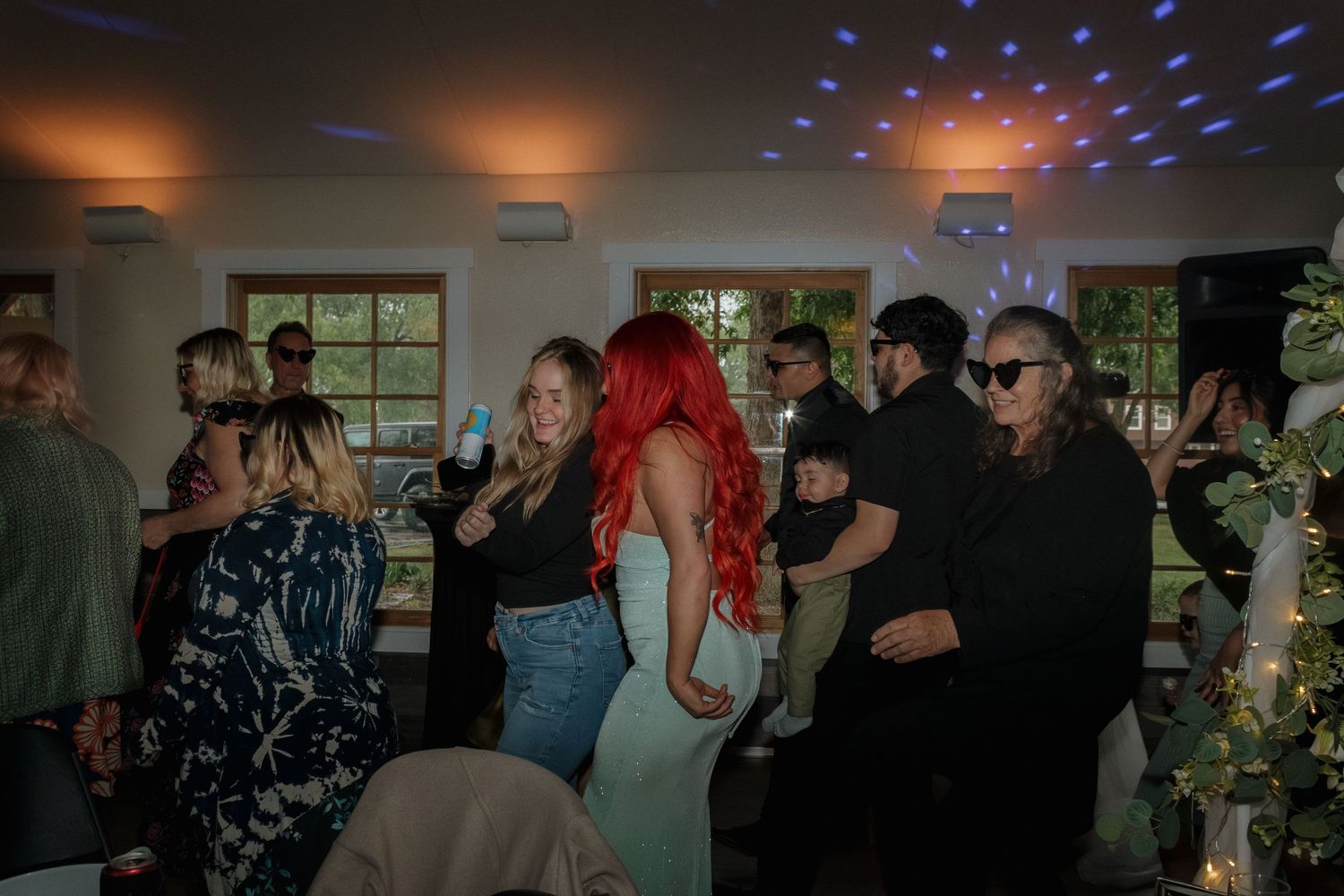 Indoor celebration with disco lights casting blue and red dots across the ceiling.