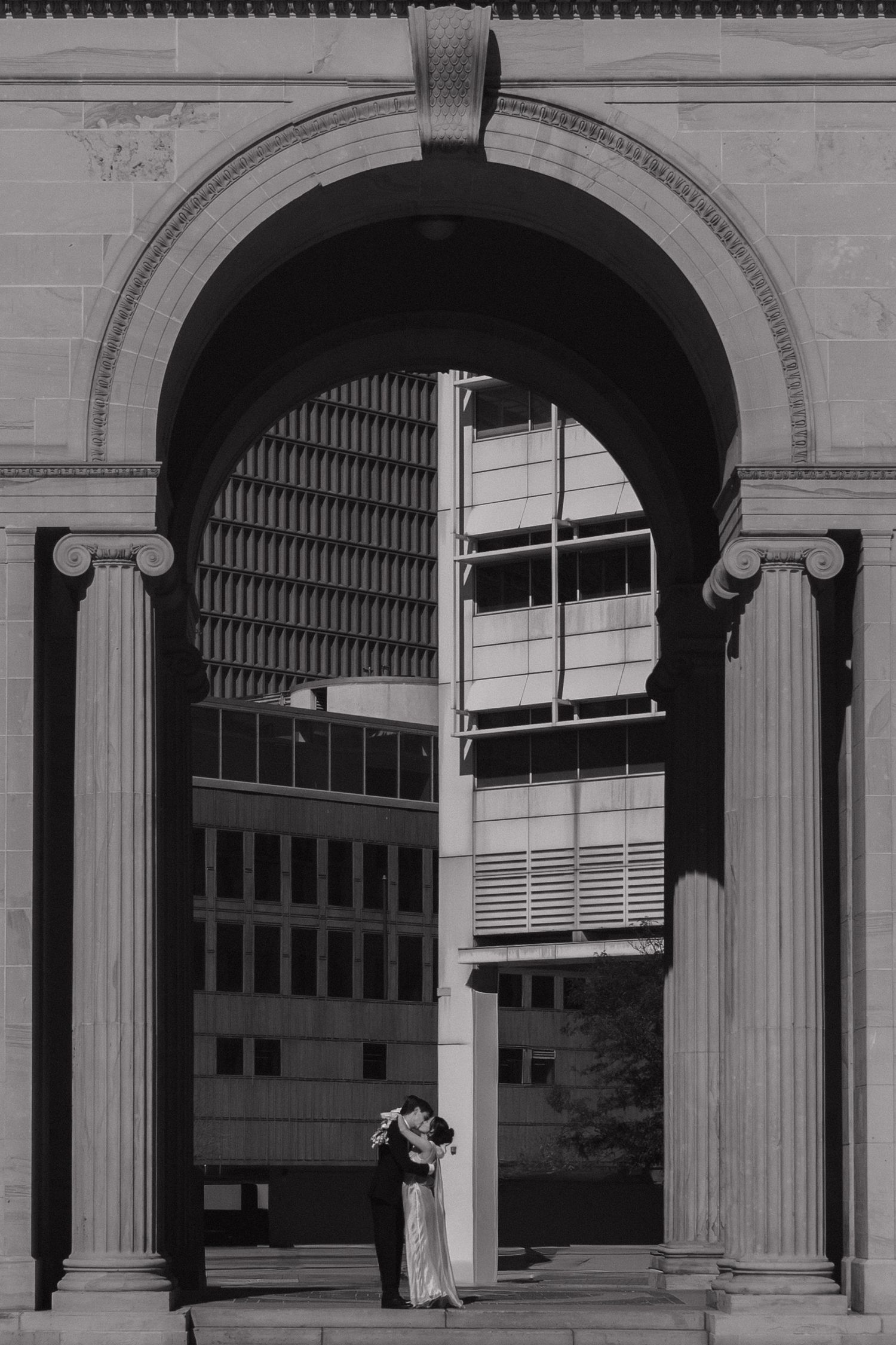 Classical stone colonnade with Ionic columns casting dramatic shadows.