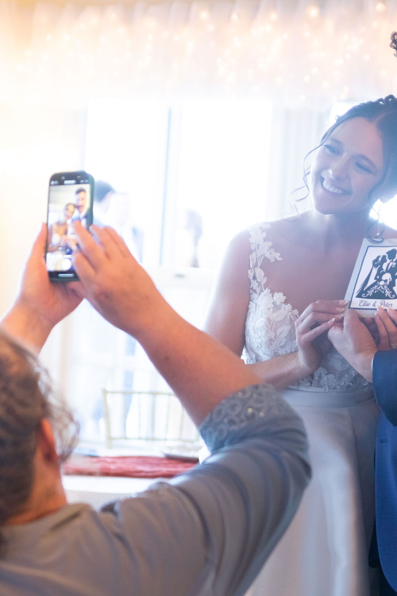 Wedding guests taking selfie photos together at a celebration.