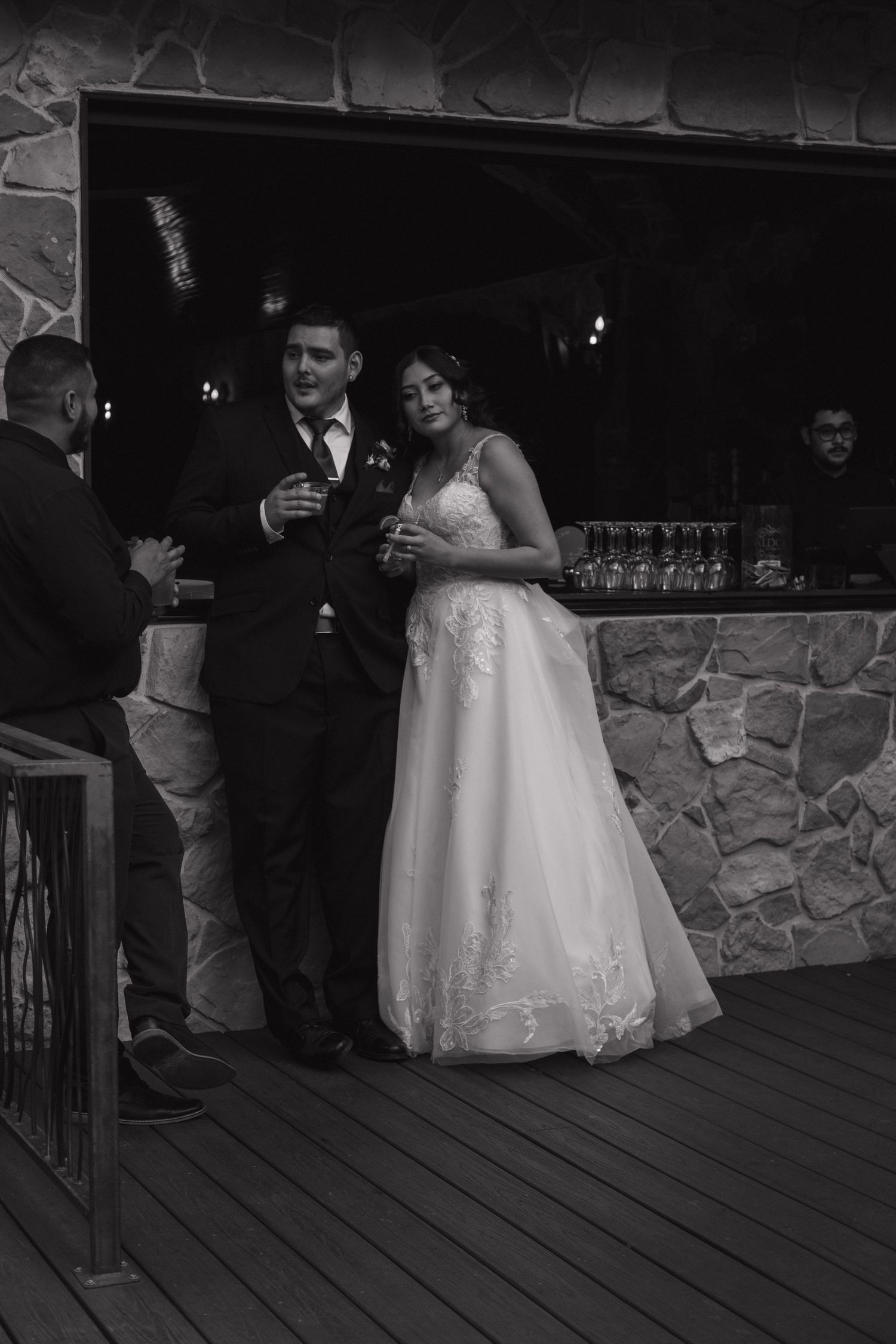 Bride and groom standing together at the bar in black and white photo during their wedding reception.