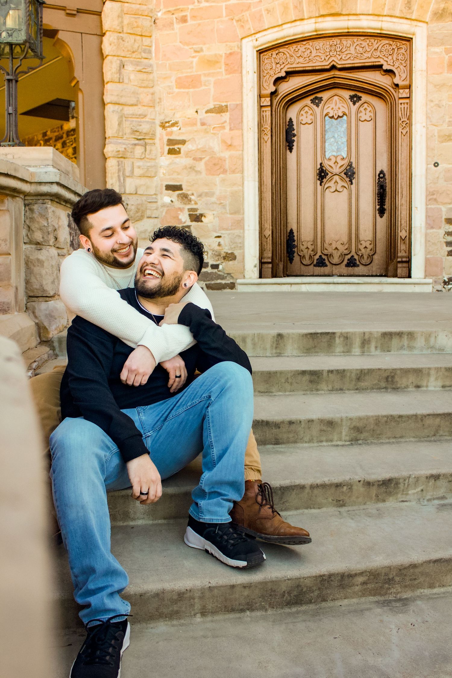 Natural candid moments shared between two people on the steps of a stone building.