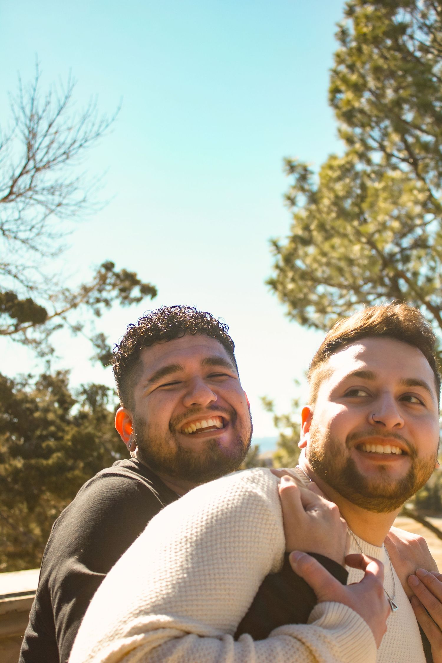 A candid shot of two people sharing a laugh in bright sunlight.