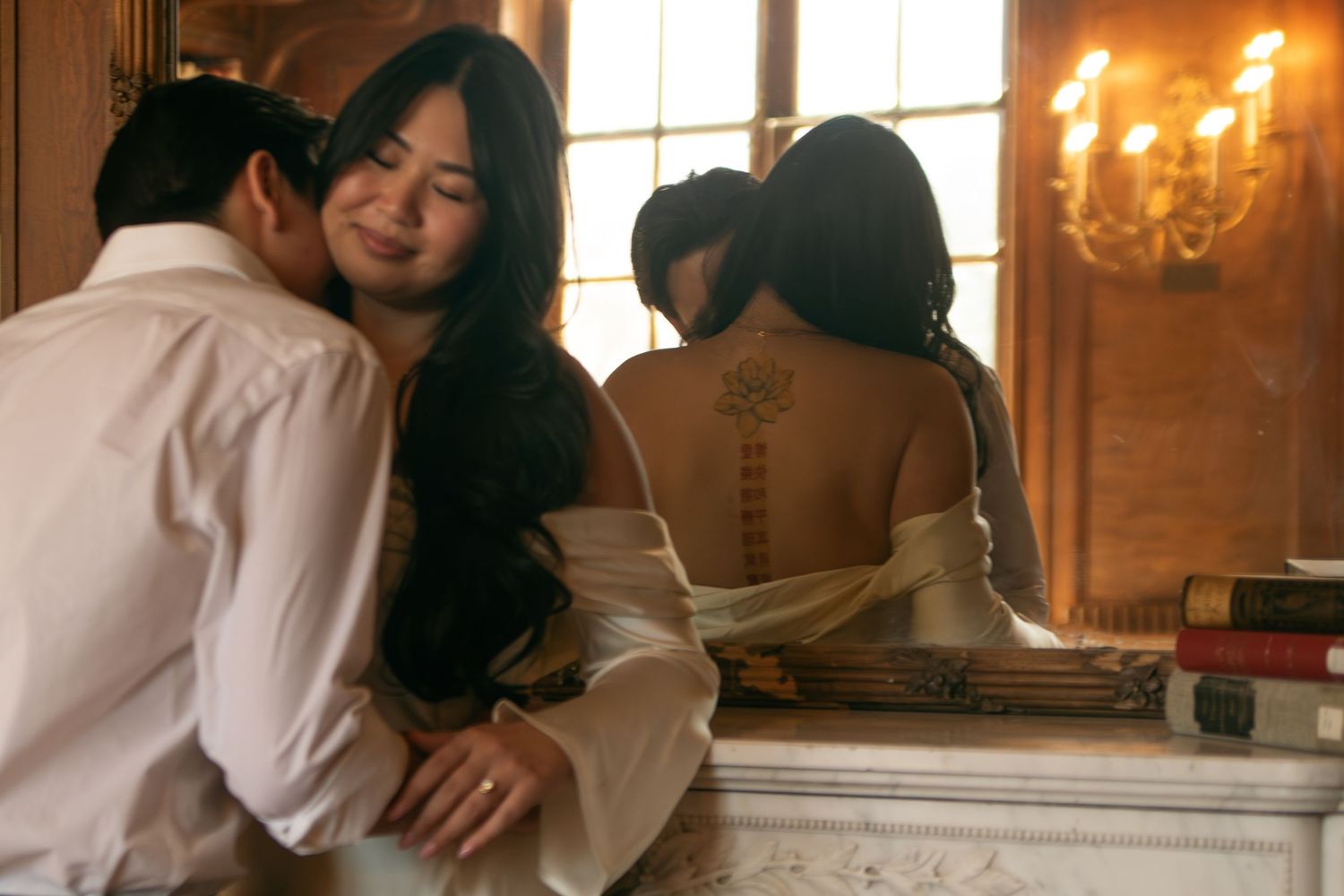 A couple shares an intimate moment near a fireplace with candlelight and books in a vintage setting.