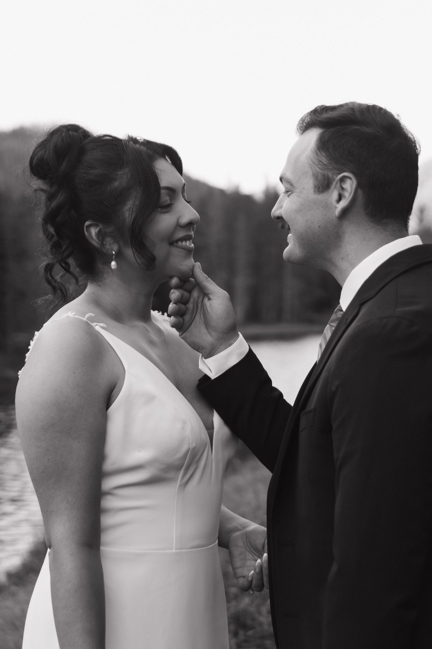 An intimate black and white wedding portrait by the water.