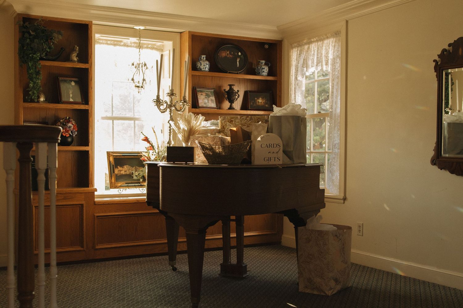 Warm interior scene with a baby grand piano and natural light streaming through windows.