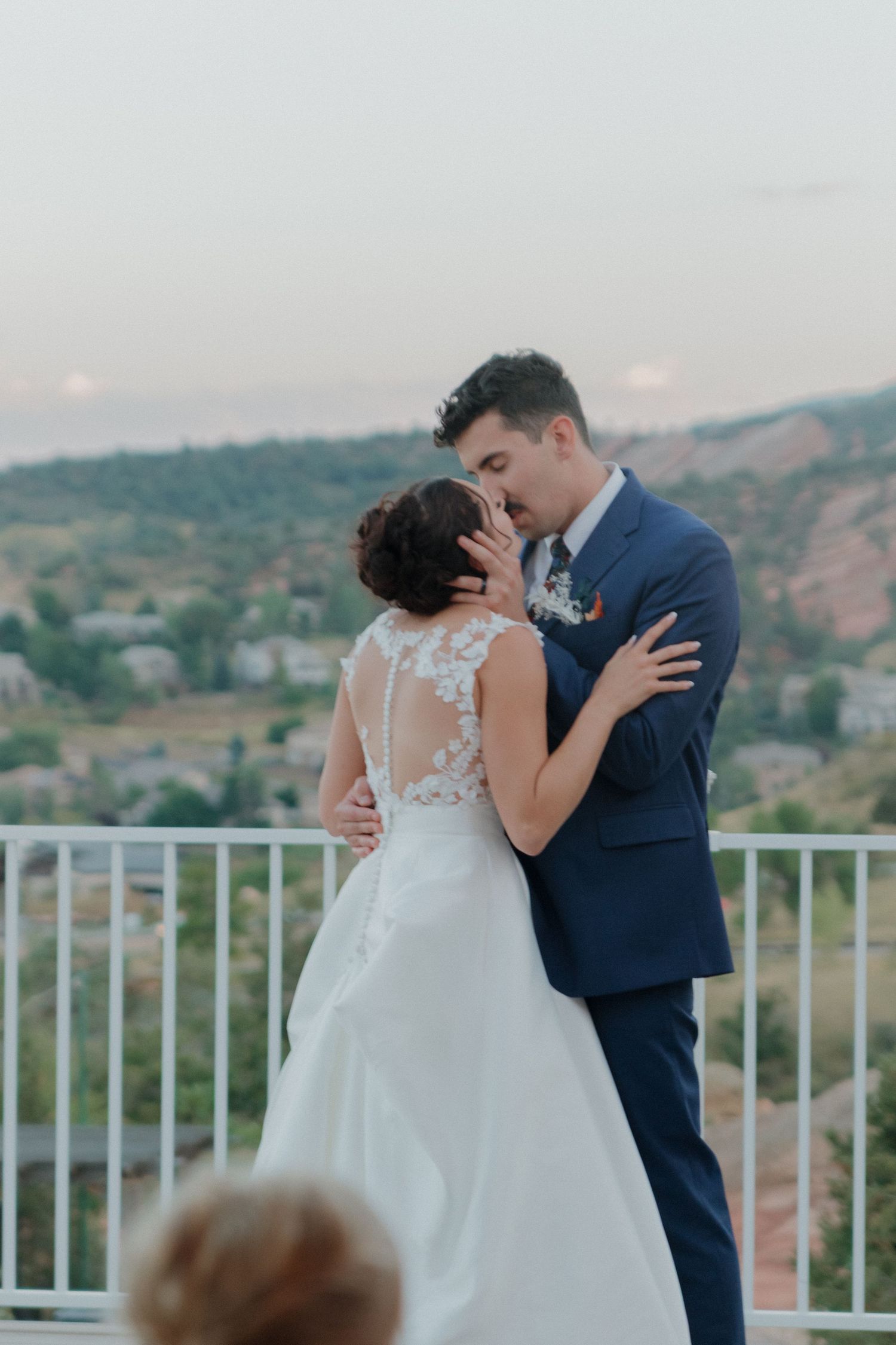 Romantic first dance moment shared on deck overlooking mountain landscape.