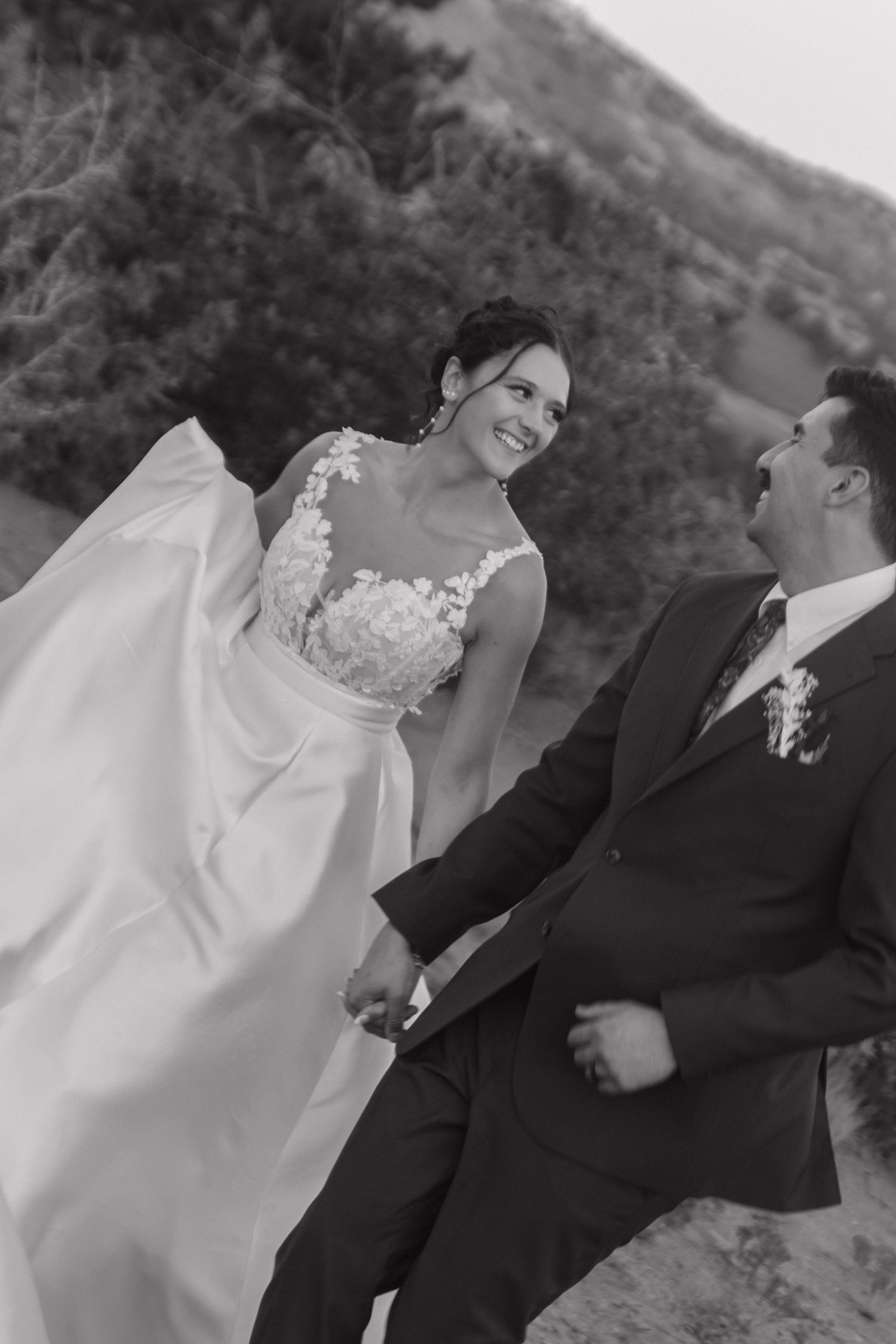 Intimate wedding moment captured in black and white against mountain backdrop.