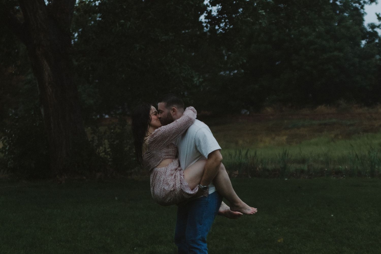 A tender moment between two people sitting in a grassy field during golden hour.
