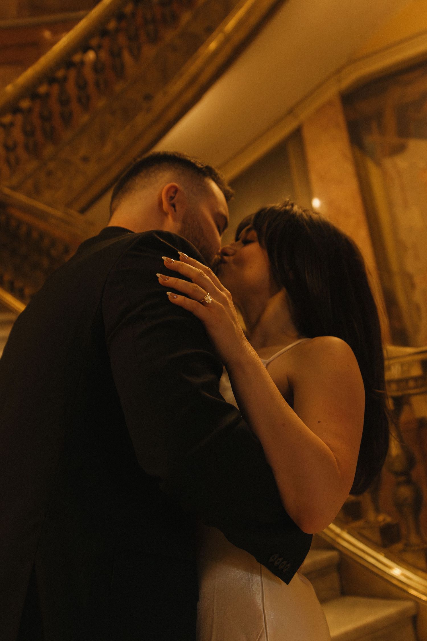 Intimate moment captured on vintage staircase with ornate details.