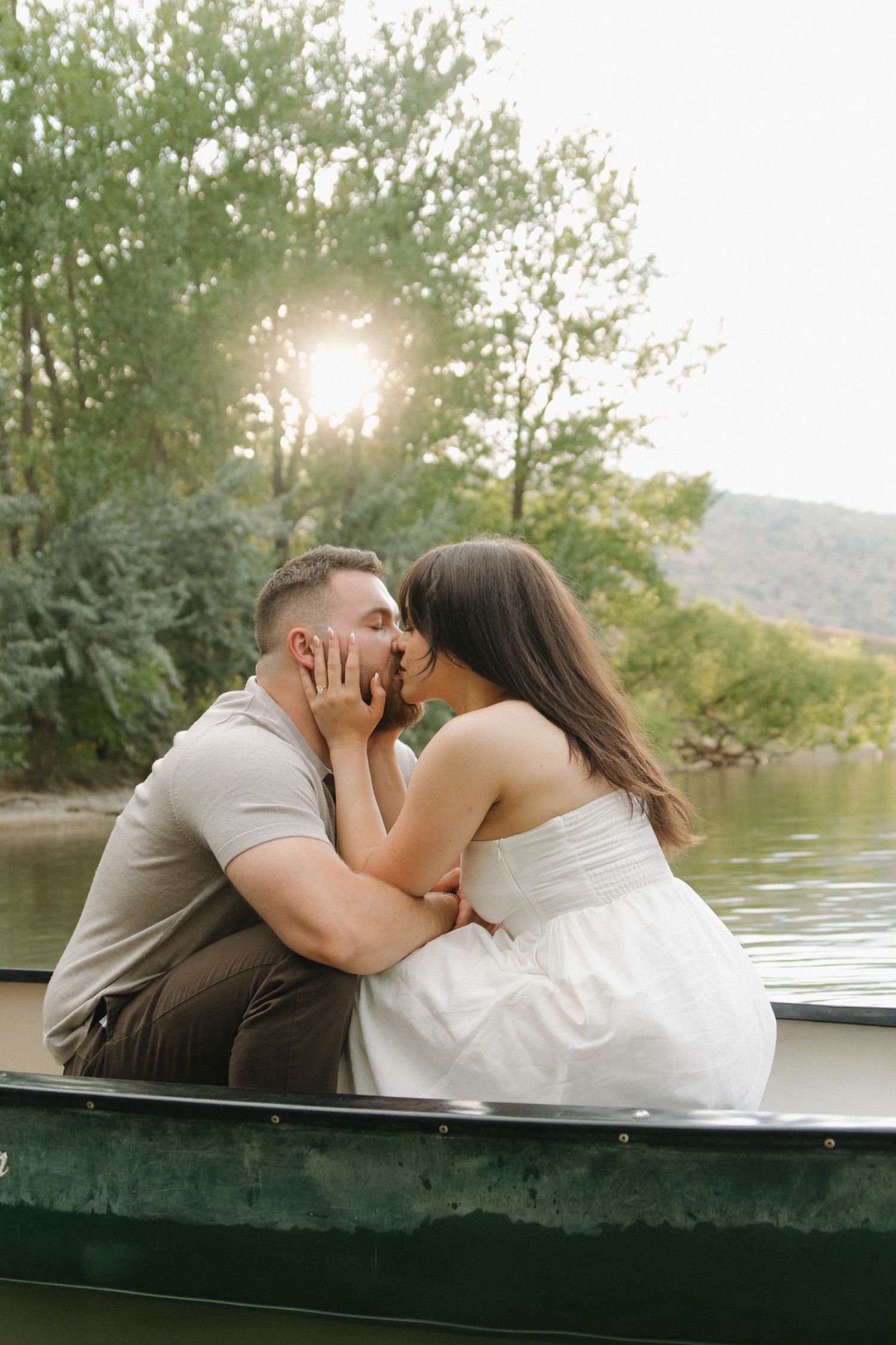 Romantic couple's photoshoot on a boat during golden hour.