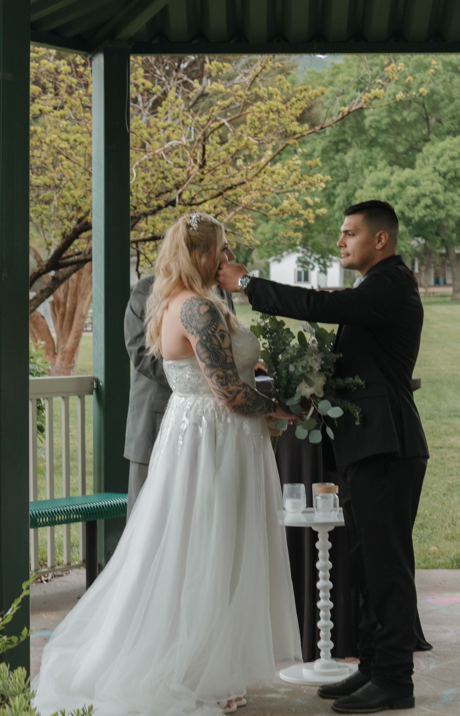 A tender moment between newlyweds during their gazebo wedding ceremony.