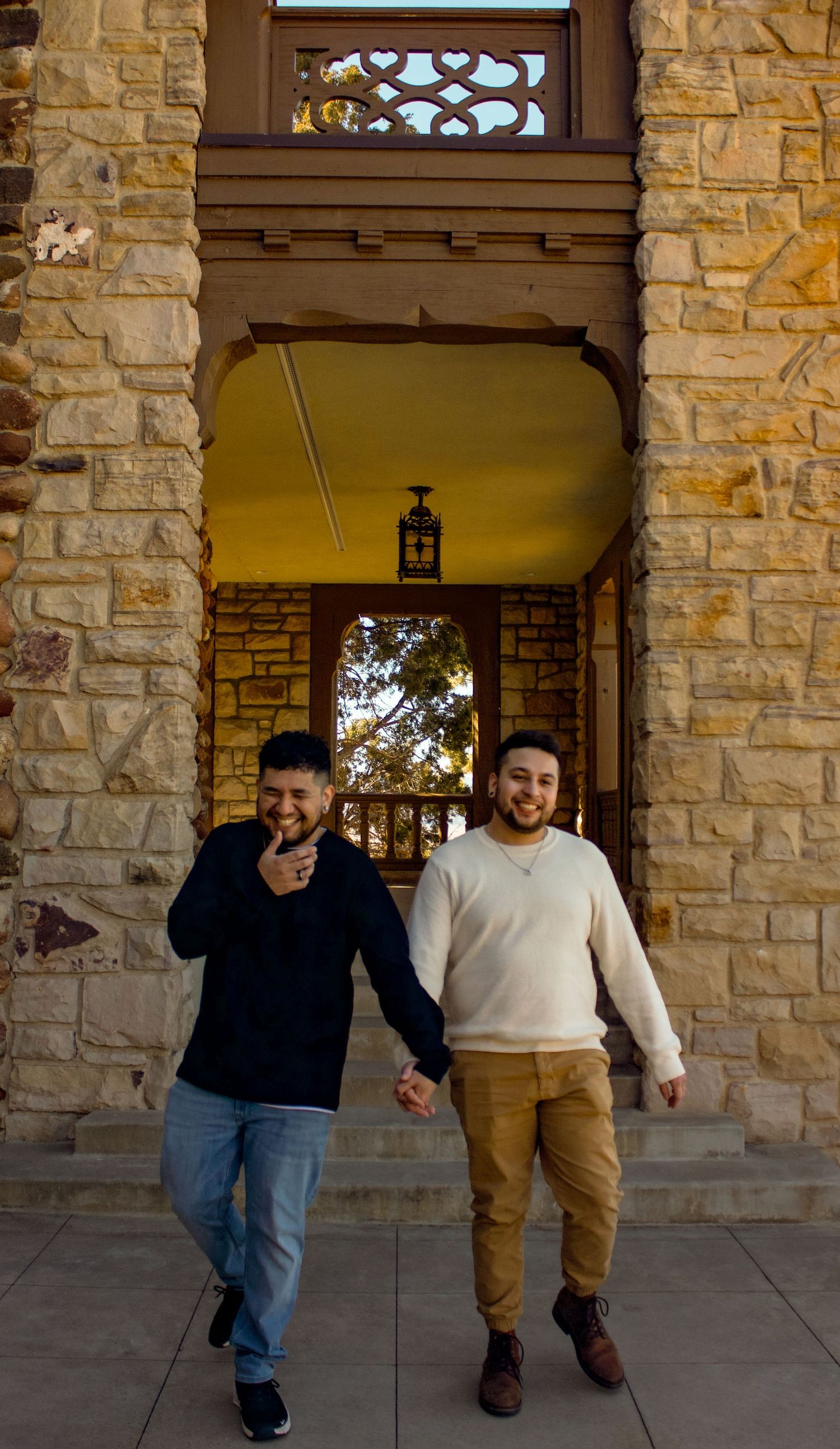 People walking together along a stone-walled building exterior.