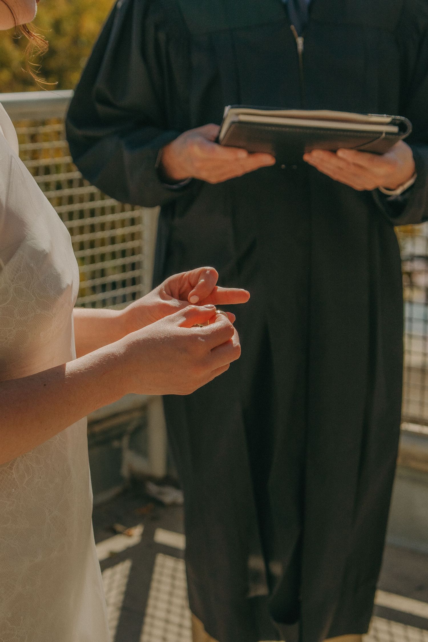 Detailed shot of hands during a wedding ceremony with an officiant holding a book.