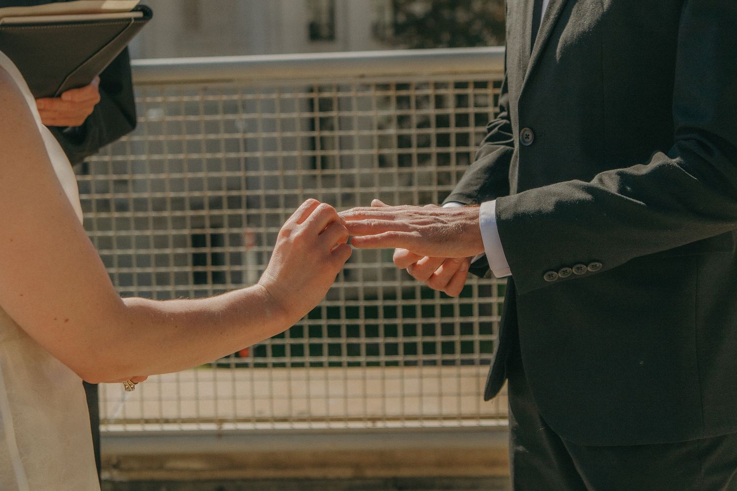 Close-up shots of hands exchanging documents during wedding ceremony.