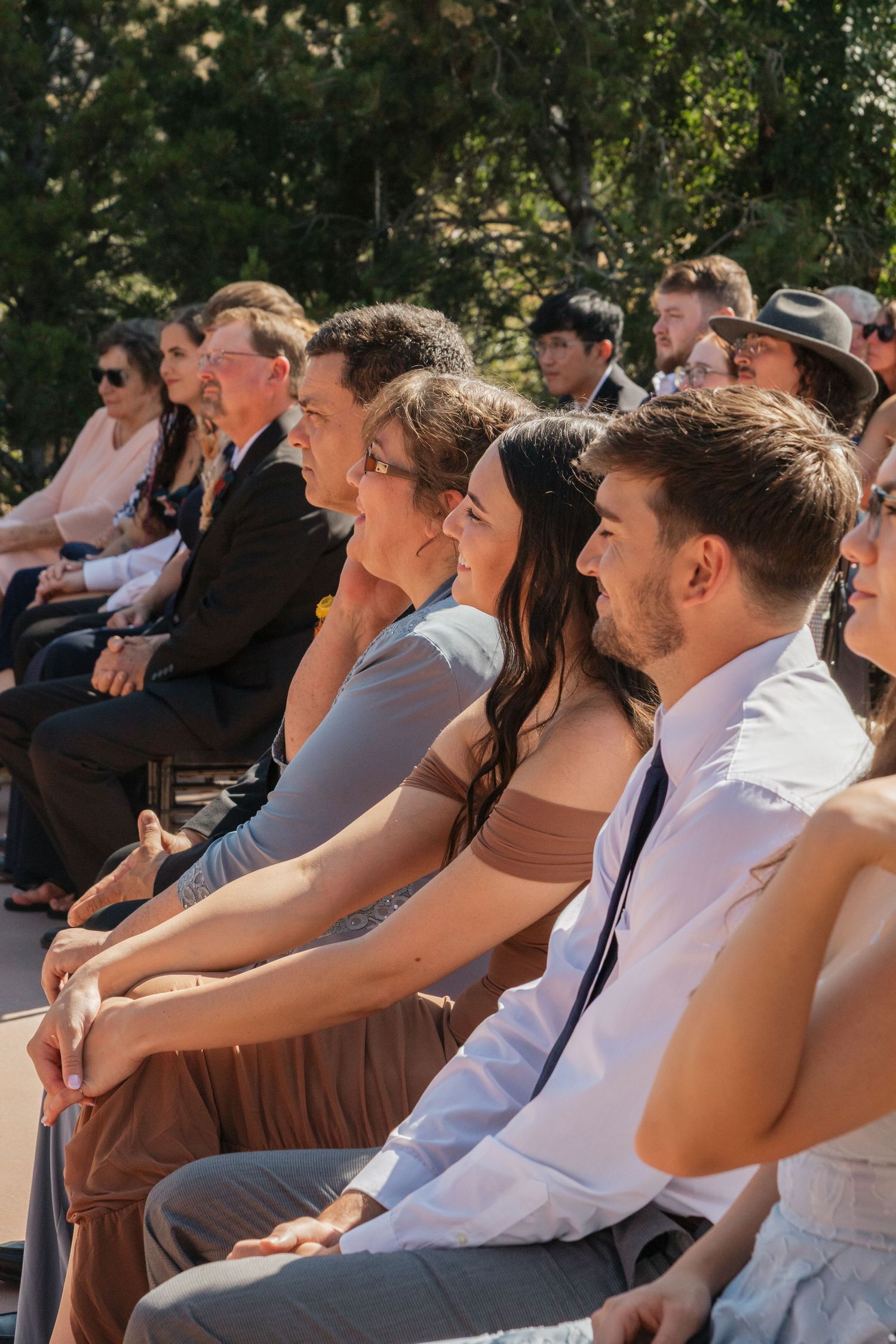 Wedding guests seated in rows during an outdoor daytime ceremony.