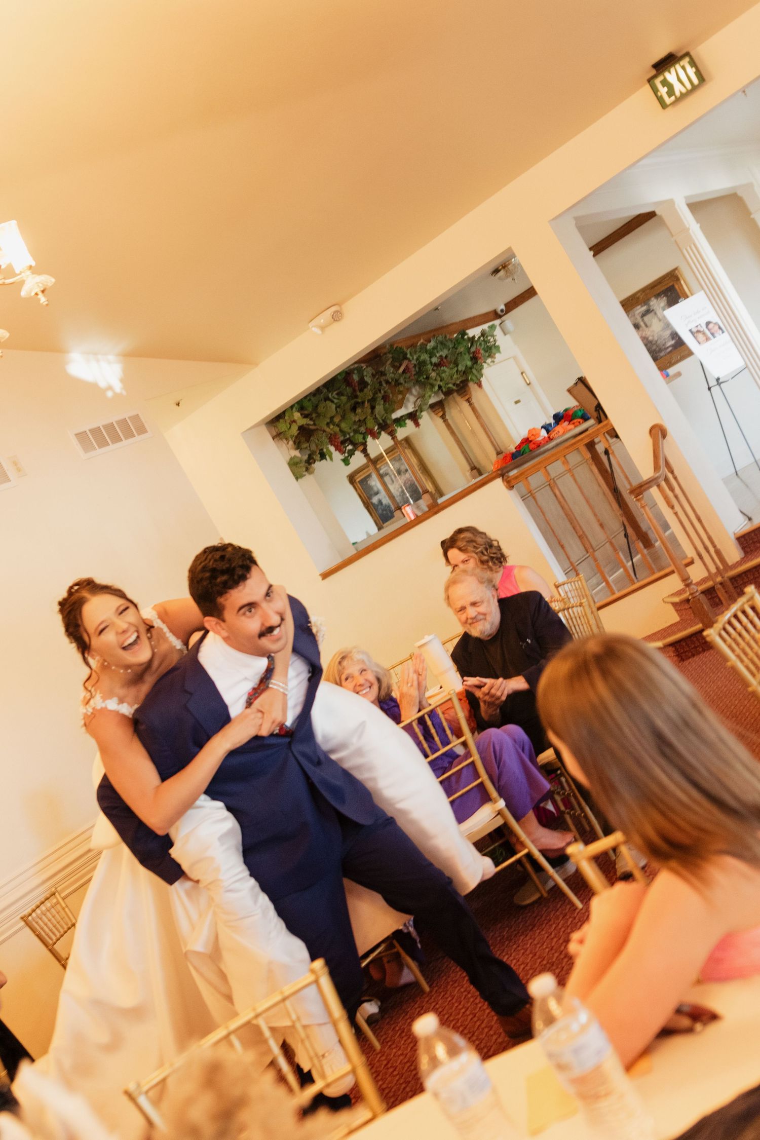 Reception celebration with dancing and laughter in an indoor venue.